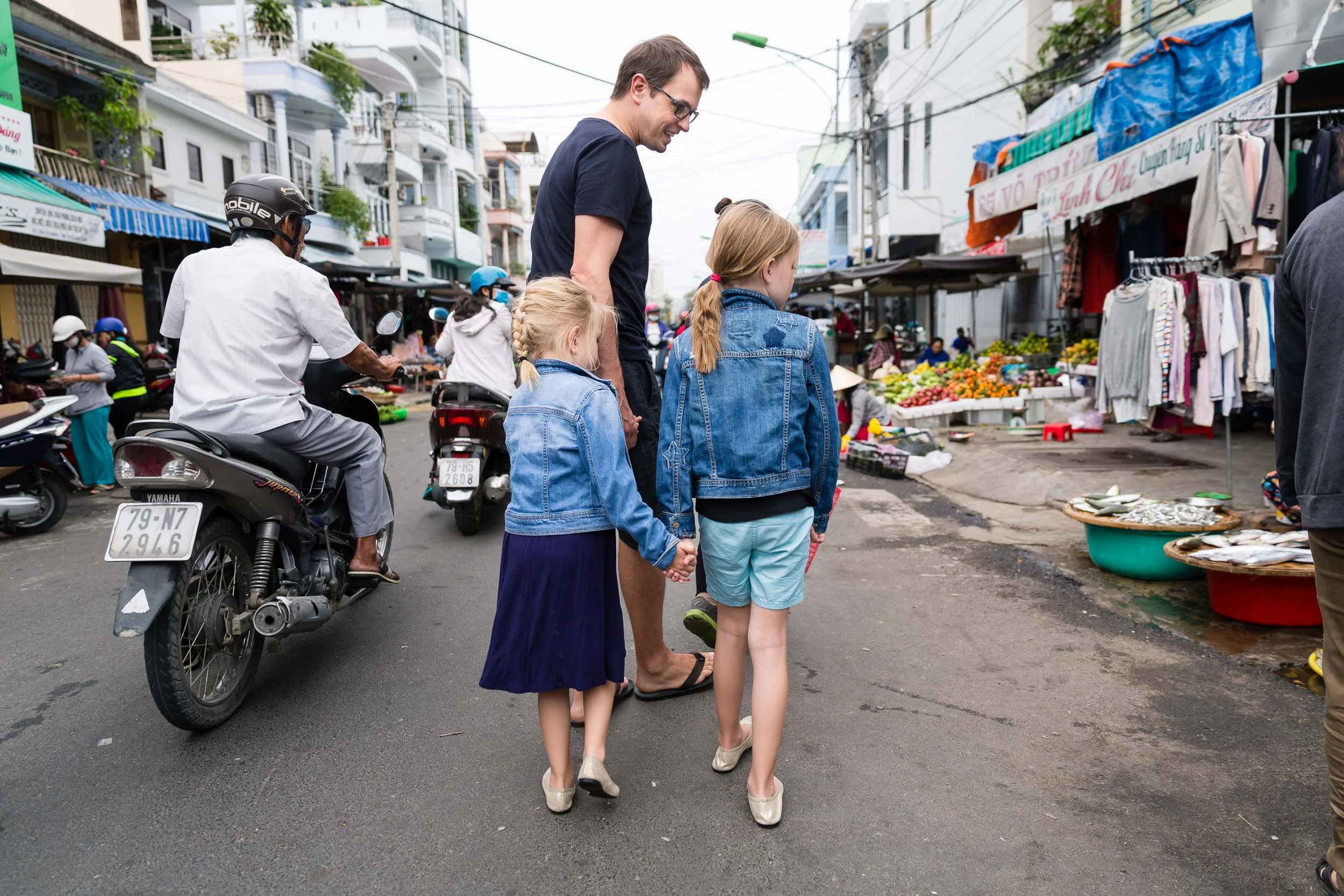 dad_and_daughters_in_blue_walking_in_vietnamese_market_Personal_portfolio_by_rebecca_hunnicutt_farren.jpg