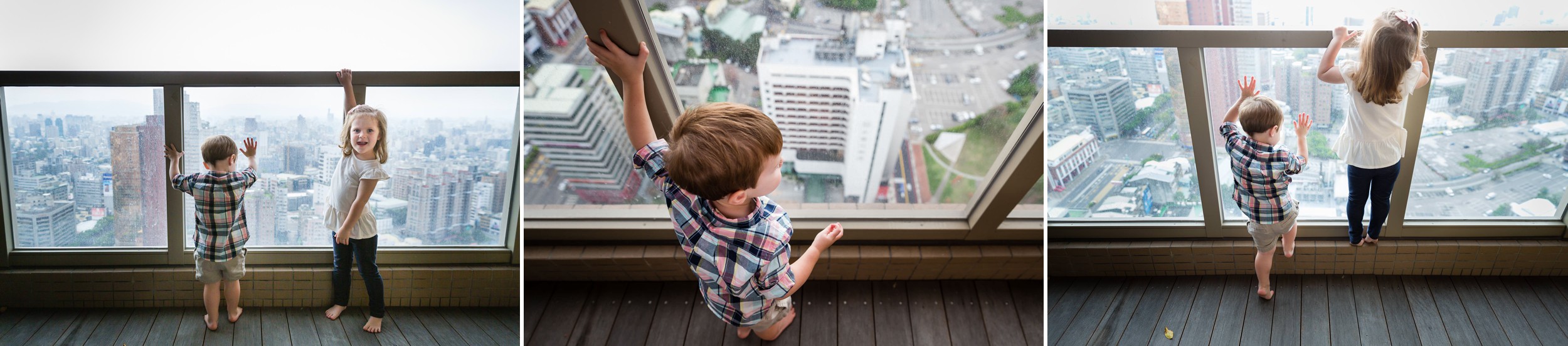 Brother and sister looking out at the city of Taichung, Taiwan from their balcony.