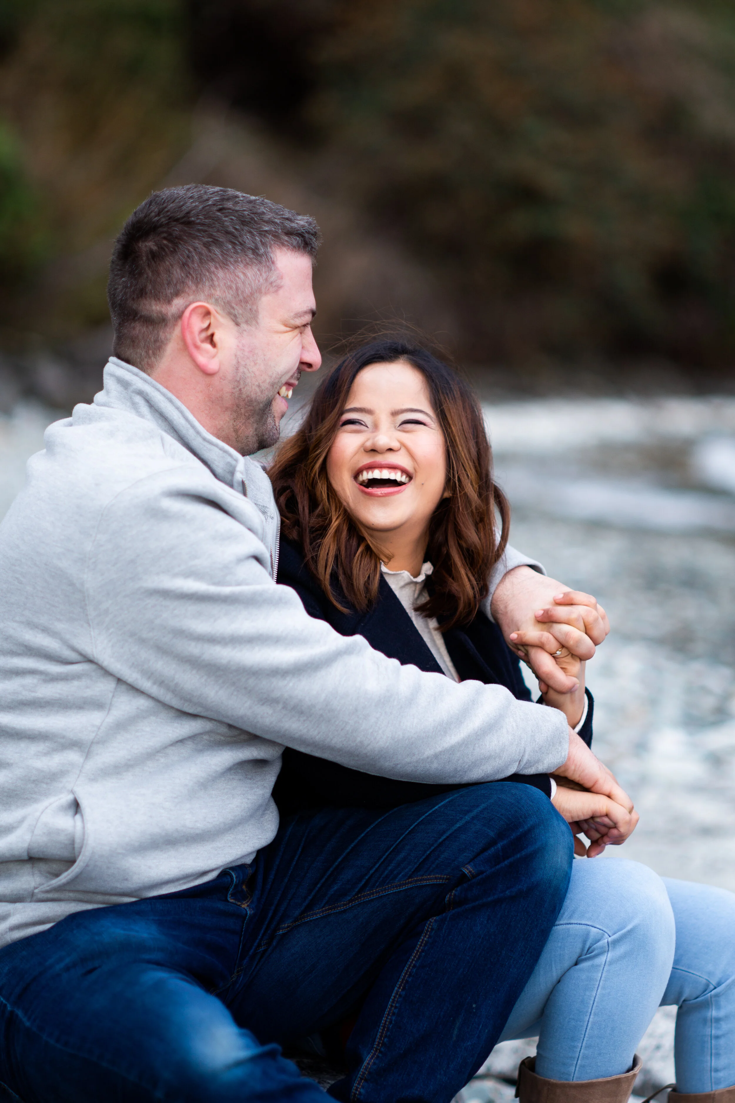 Hugging couple smiling on lakeside