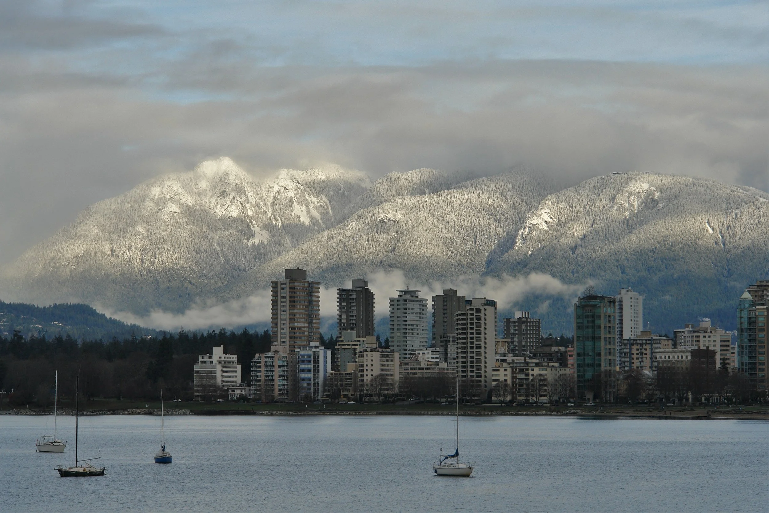 Waterfront view of Vancouver buildings with mountains in the background