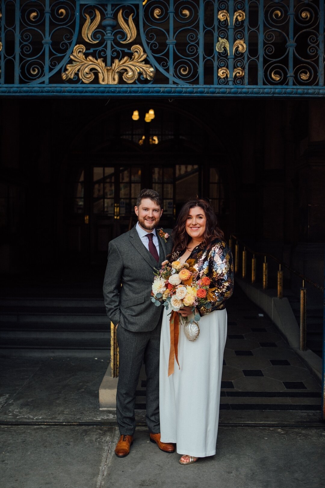 Such a lovely shot of Holly and Dan post-I-do's at Sheffield Town Hall. Holly wore our Forget Me Not jumpsuit with added floaty silk georgette sleeves, and paired it with this divine sparkly @rixo jacket, plus killer @swallowsanddamsons blooms. 
Look