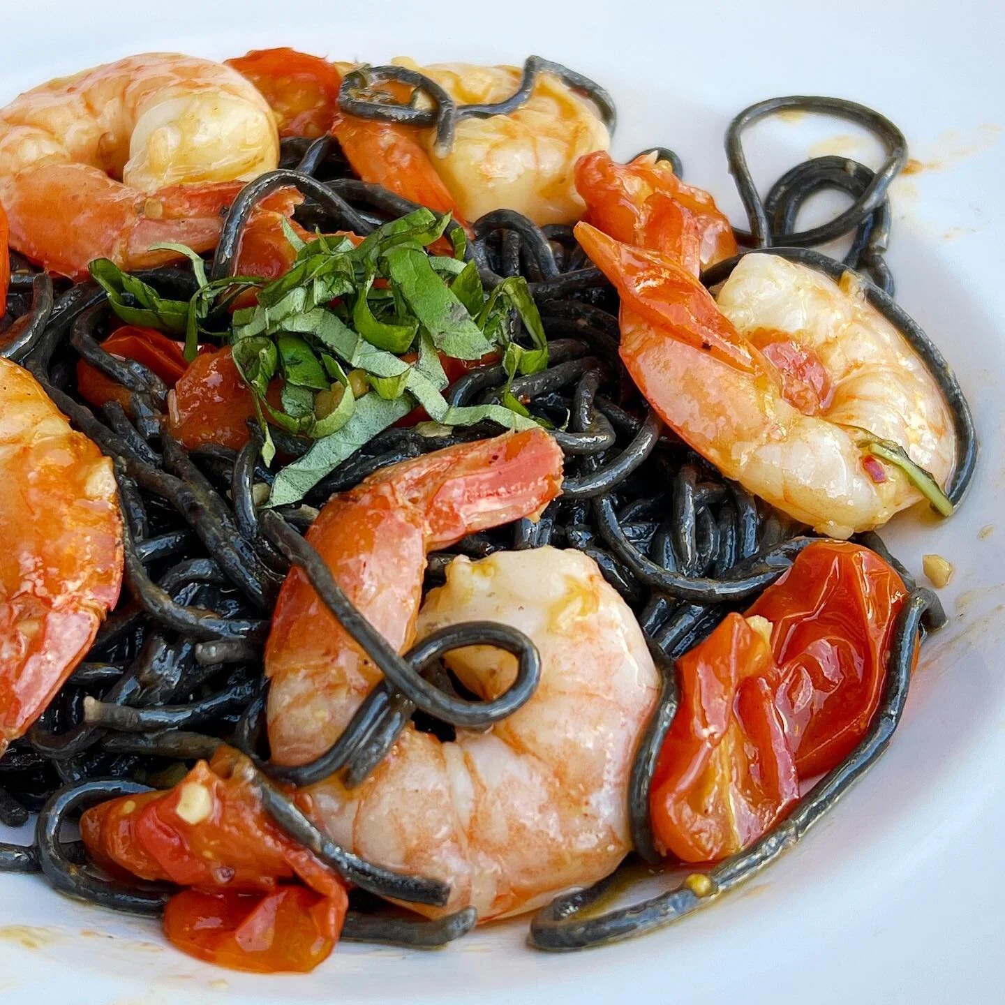 Squid ink pasta seems to be my go-to whenever I see it on a menu. This dish did not disappoint! These flavors were absolutely on point. 
.
.
.
.
.
.
#squidink #spaghettiallachitarra #jumbogulfshrimp #seafood #pasta #grapetomatoes #lemongarlicbutter #