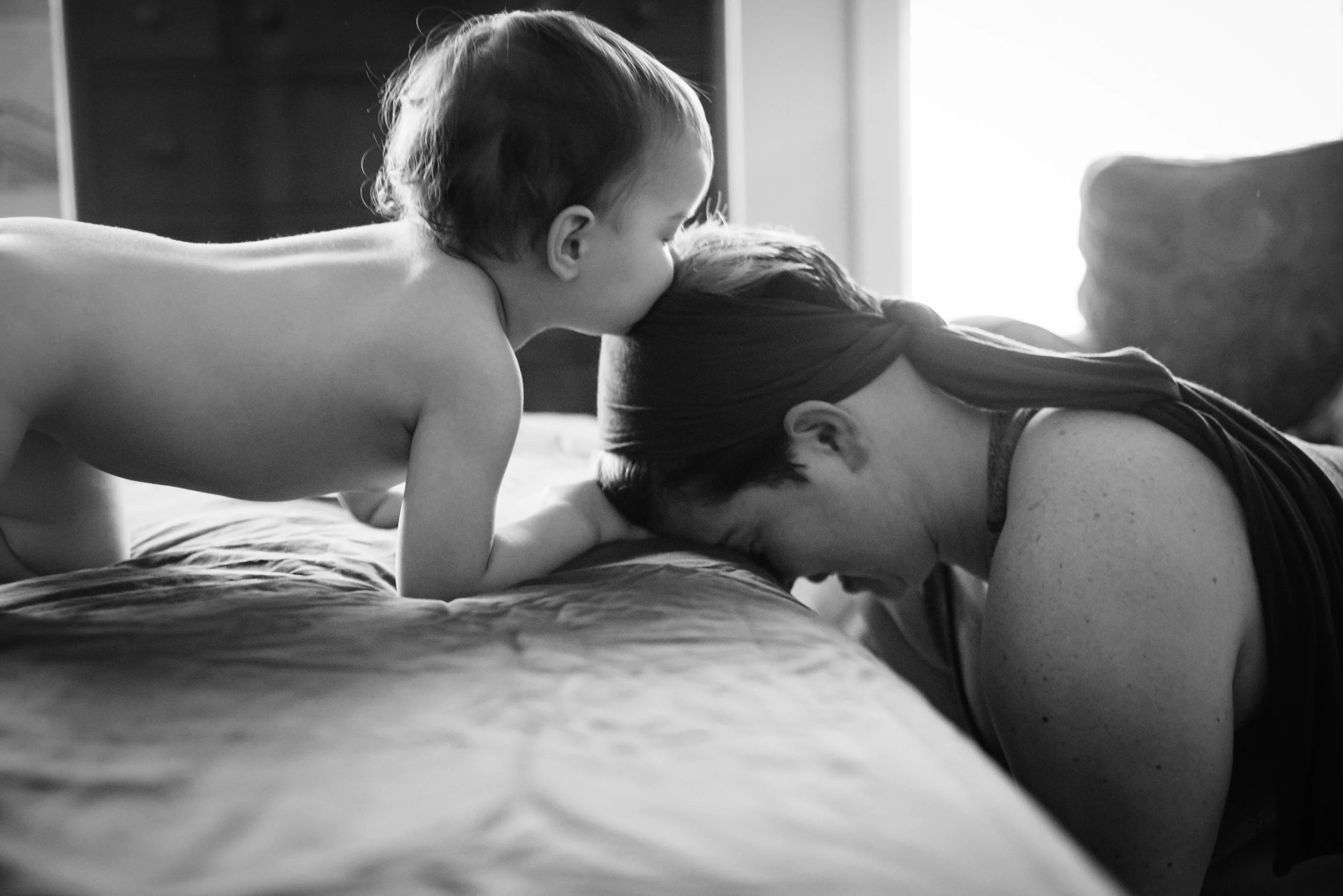 little girl kissing the top of her moms head at a home birth in Atlanta