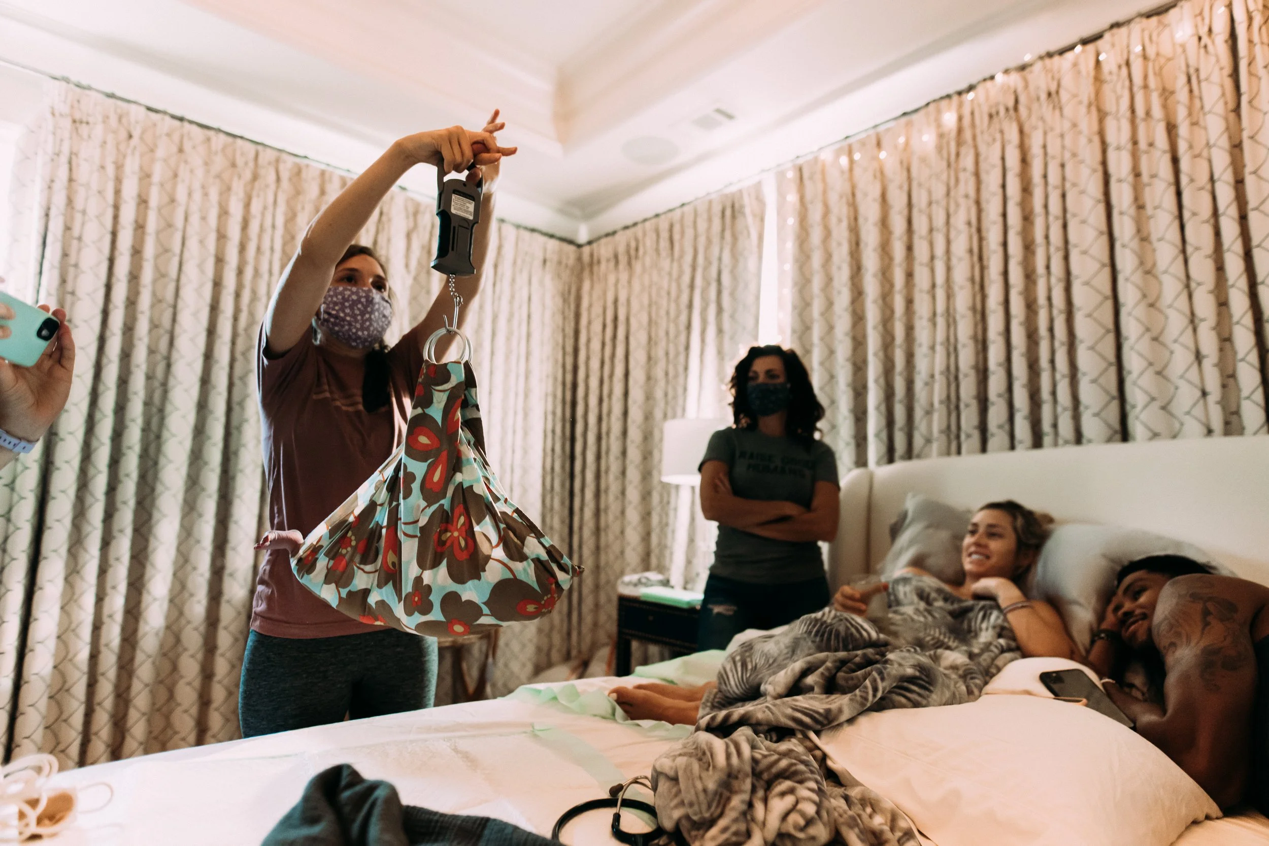 Homebirth midwife weighing a newborn baby at a home birth in Atlanta