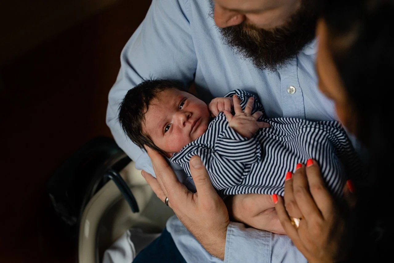 Parents holding their newborn baby at their hospital fresh48 session