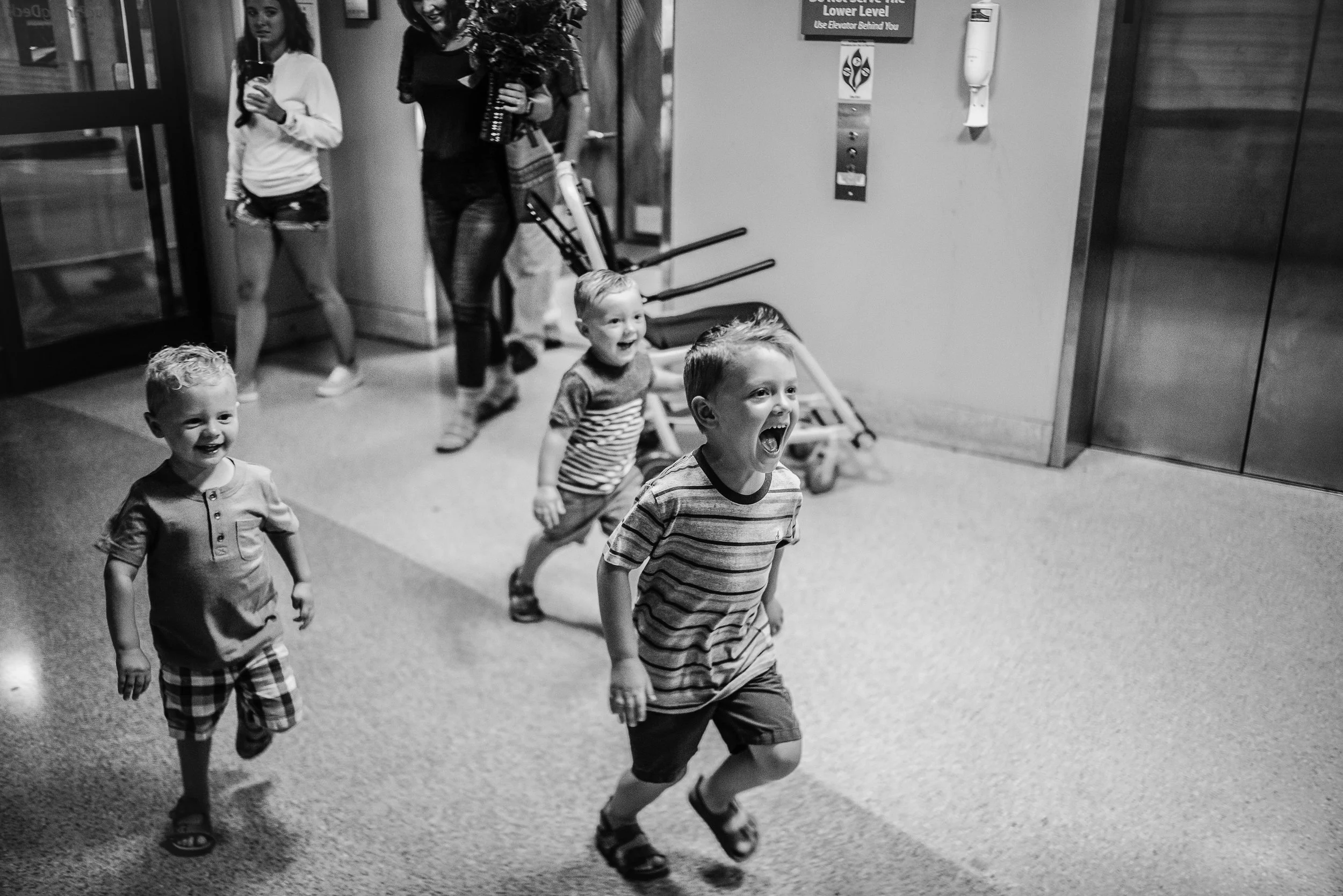 Siblings running through the hall at Kennestone hospital excited to meet their baby sister