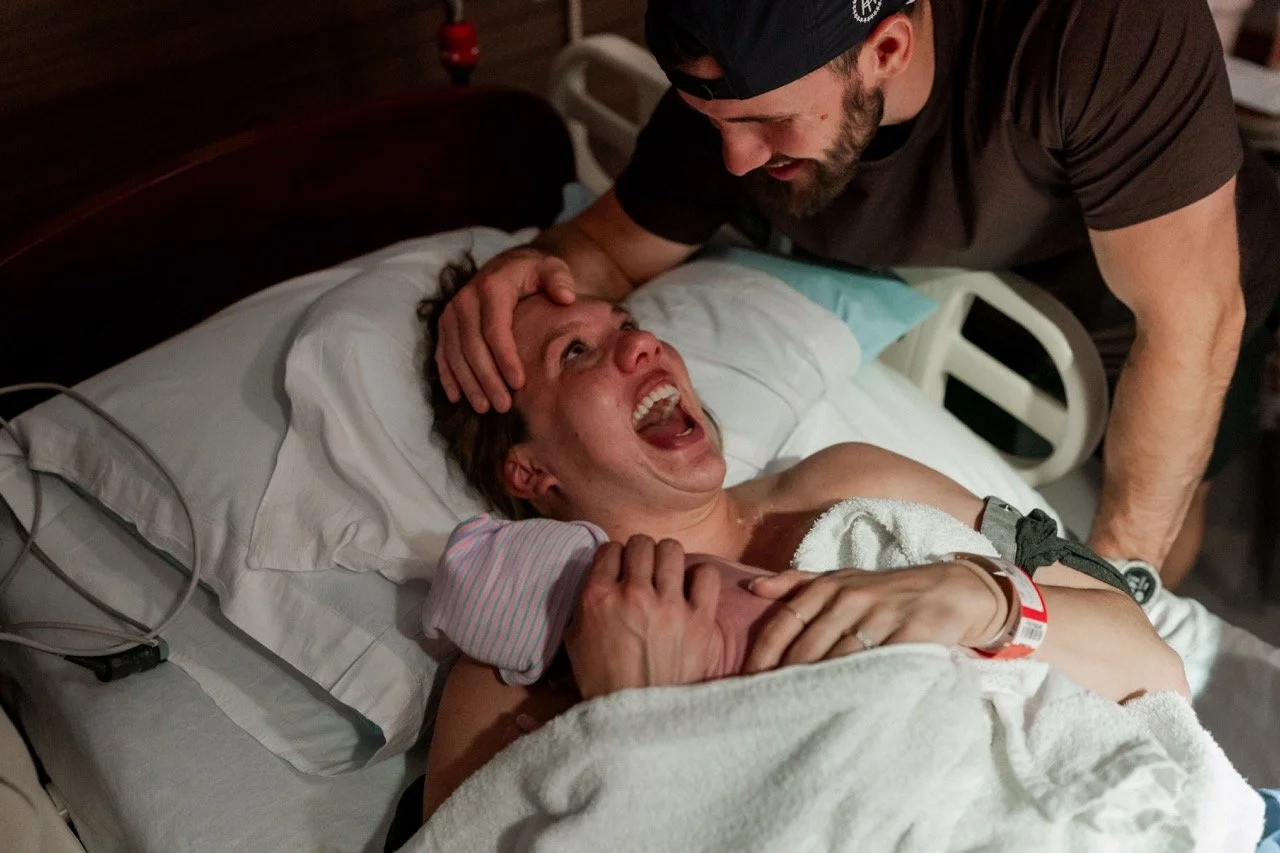 New parents laughing and holding their newborn just after birth at Piedmont Hospital Atlanta