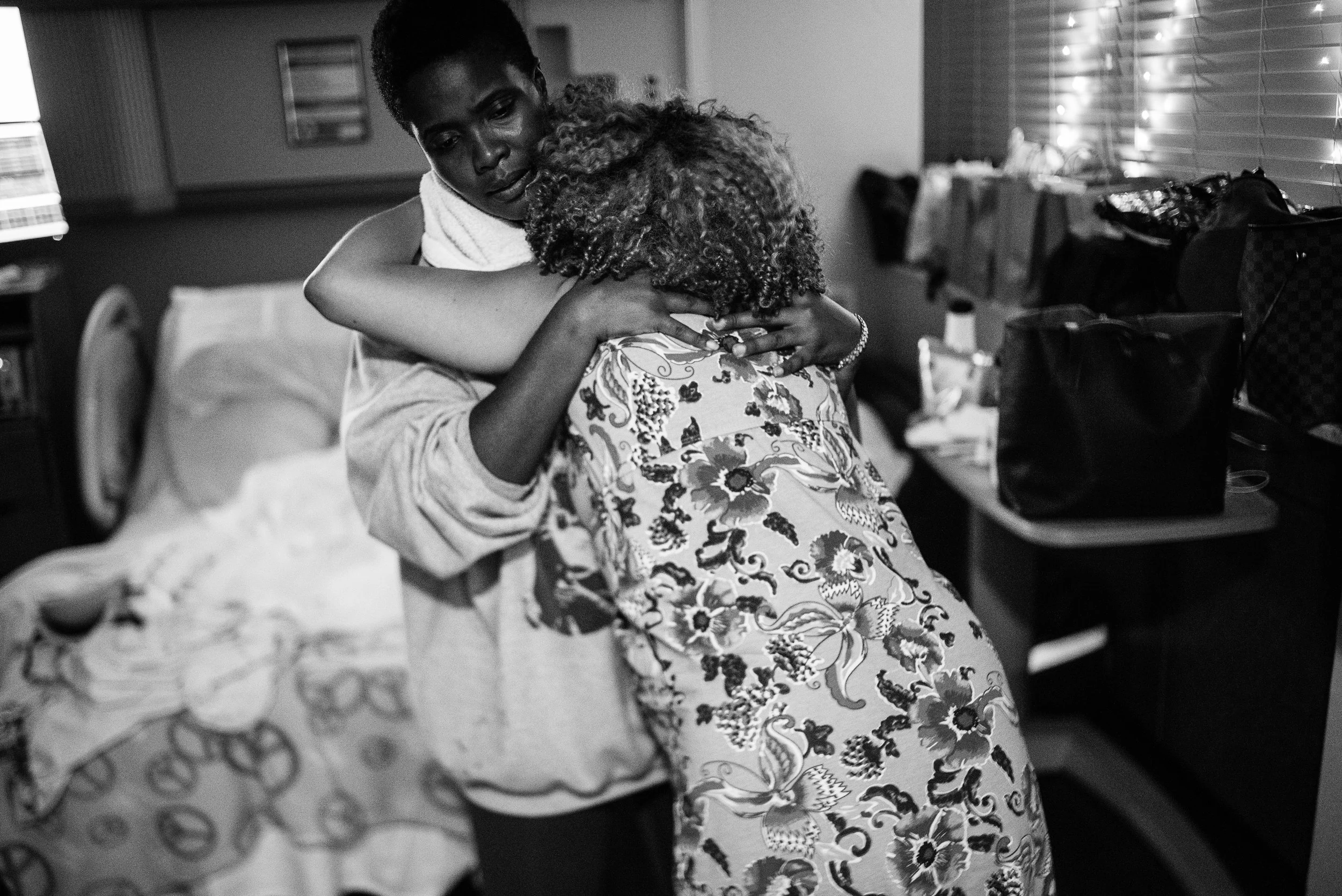 Doula holding up a mom who is in labor in the hospital