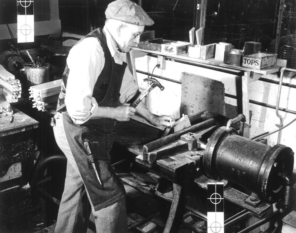 La-Z-Boy Incorporated employee applying dowels to reclining chair frames in original factory building, 1940s