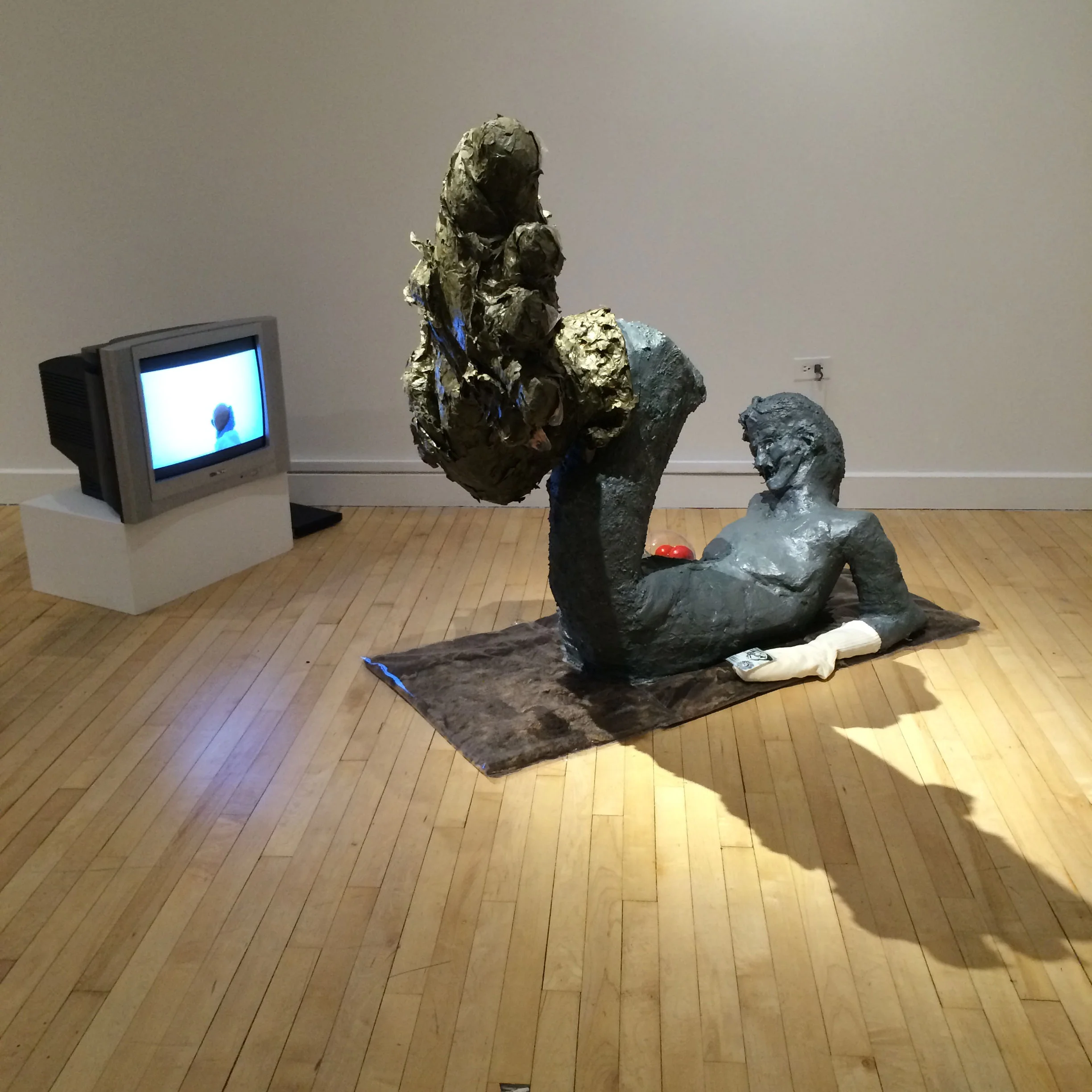Molted Shell of Sciapode watching a video of Sciapodae , 2017, 3:50 HD video (color, sound) on TV monitor, 5’ h x 2.5’ d x 4’ l, sculpture, wood, wire mesh, iron pipes, plaster, burlap, felted wool, papier-mâché, mixed paper, plastic, fake tomatoes