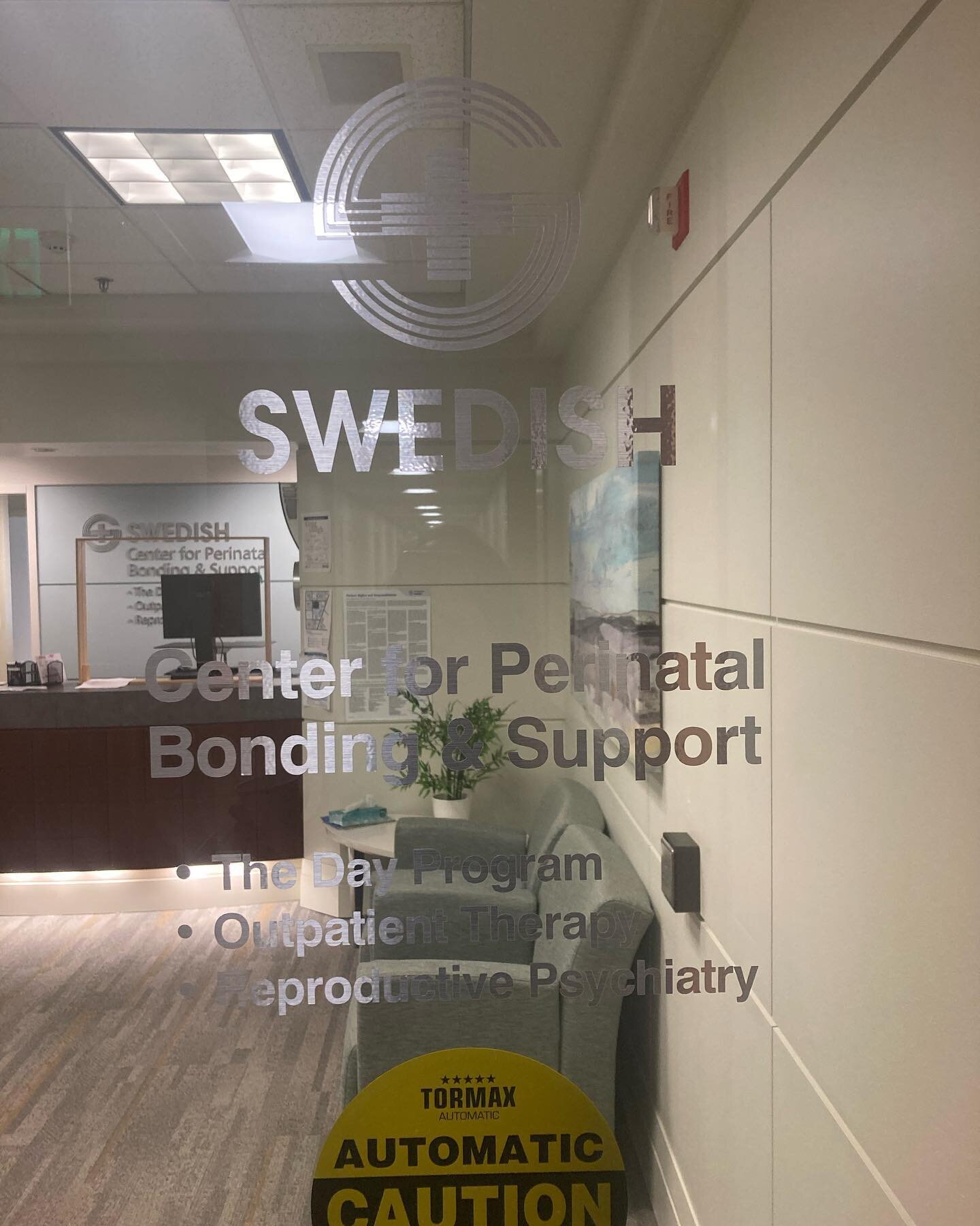 Image description: a glass door with the words Swedish Center for Perinatal Bonding and Support.  I am so excited to be joining the team at this amazing, whole-person focused center for birthing parents experiencing Postnatal mental health challenges
