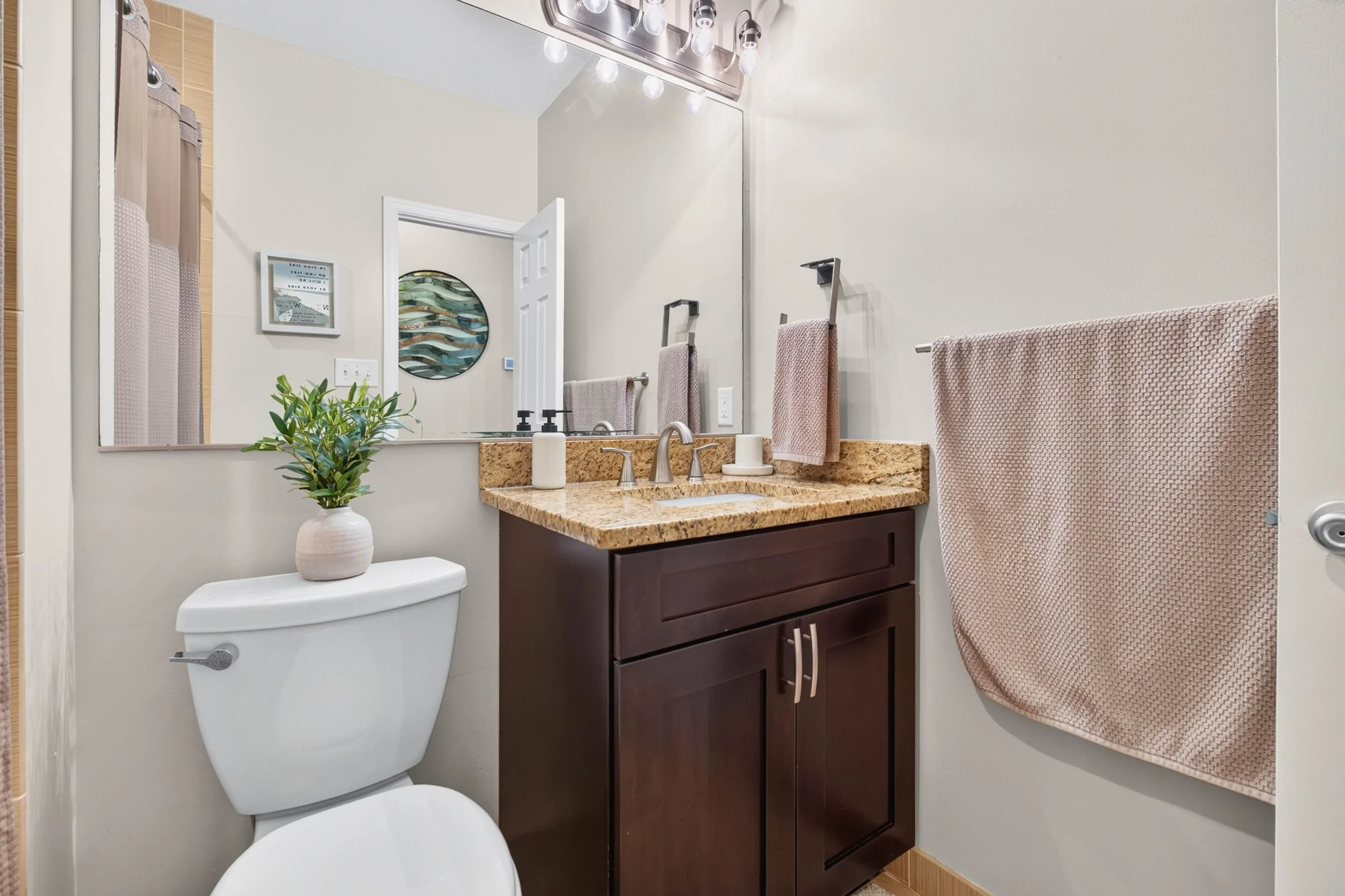 Stone counters, updated fixtures and useful storage give the hall bathroom both style and function.