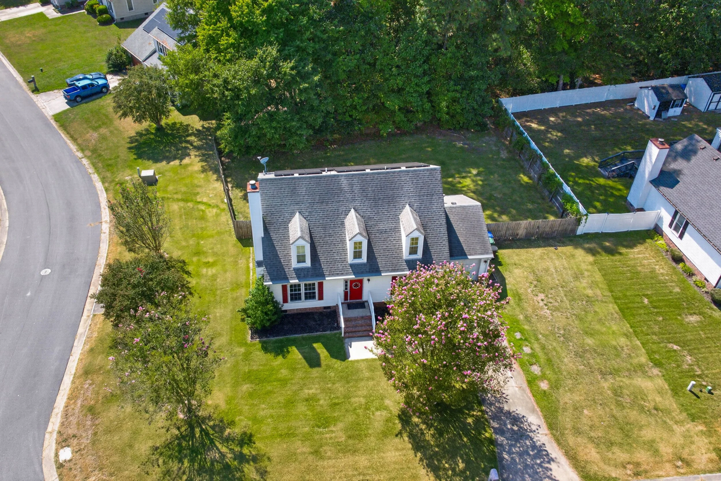 An elevated view shows 811 Haskins Drive on its corner lot, including the front lawn, attached garage and fenced backyard.