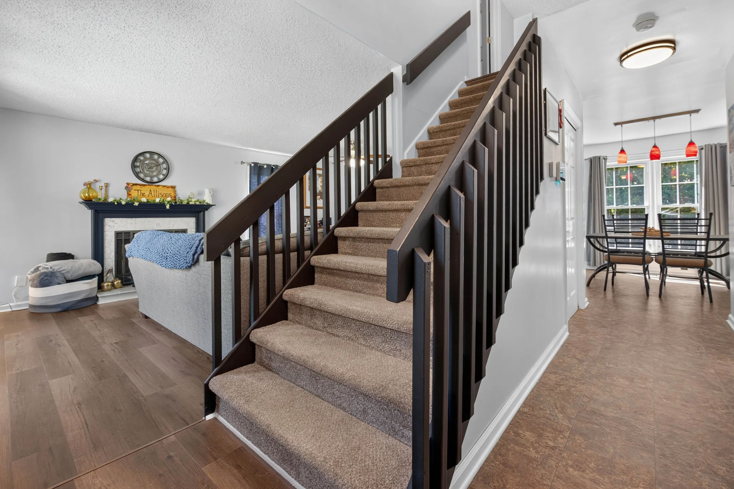 The front entry opens beside the staircase, with the living and dining areas close by.