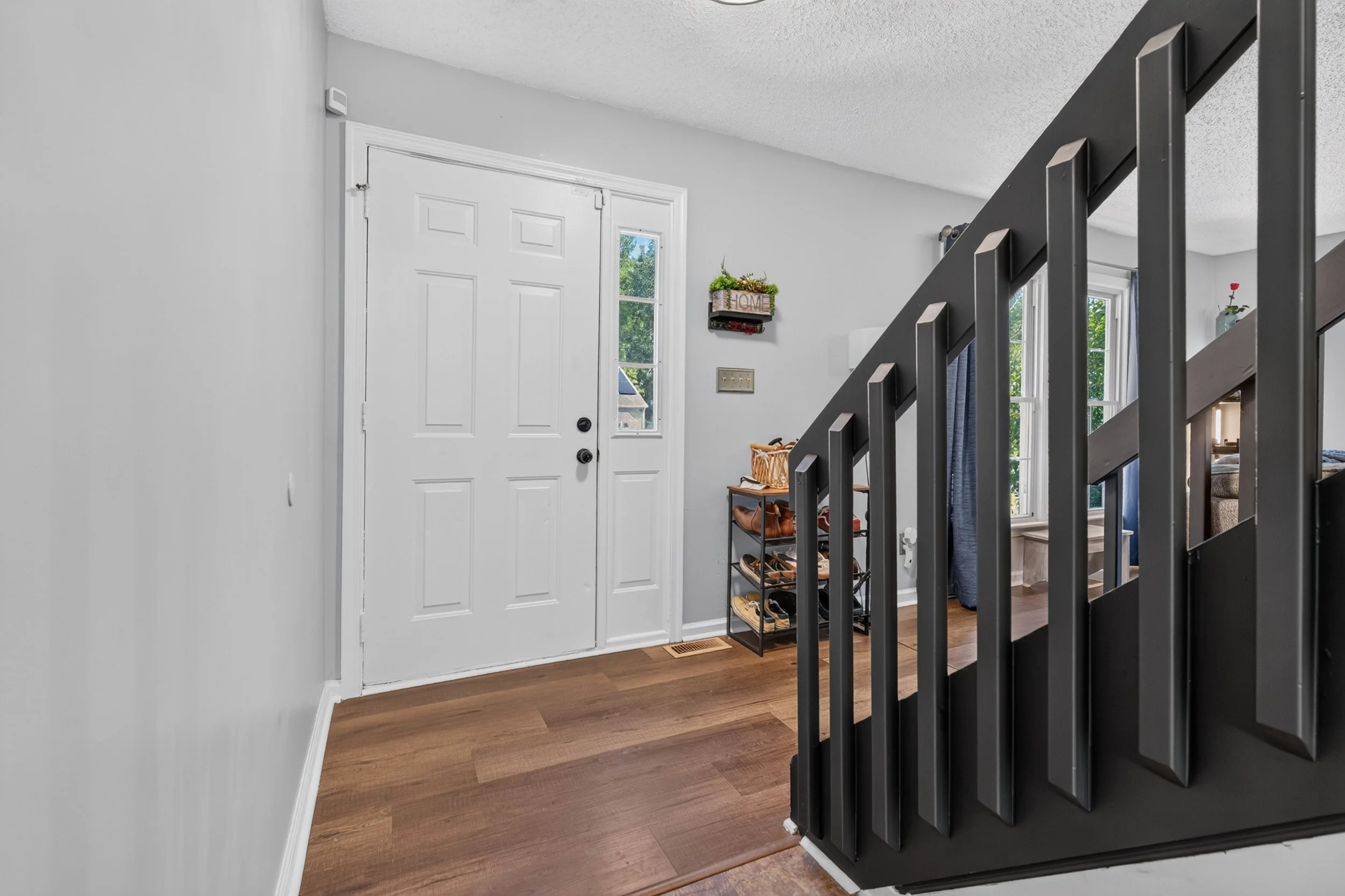 The front entry and staircase introduce the separation between the main level and three upstairs bedrooms.