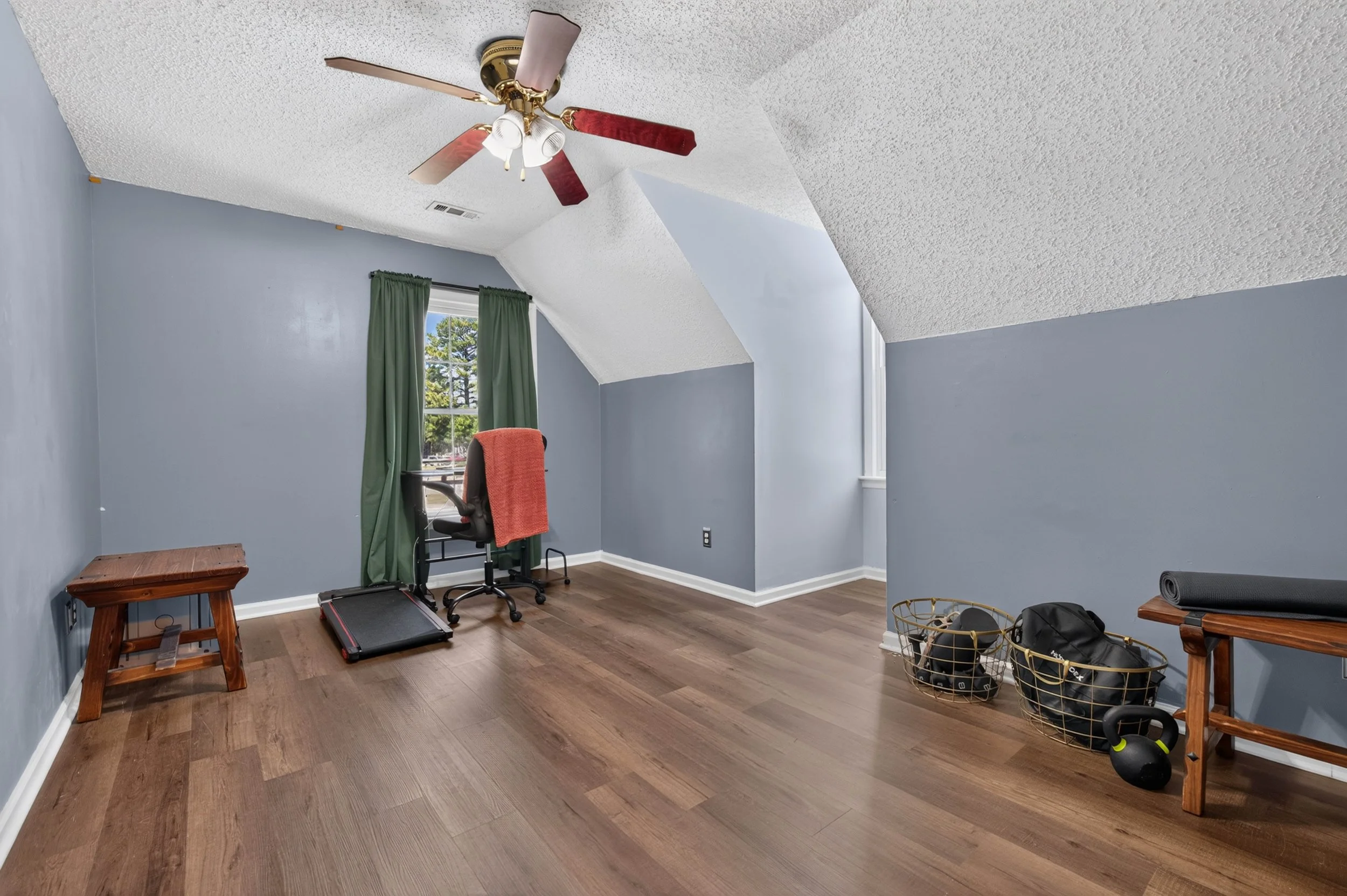 The third upstairs bedroom has a dormer-style ceiling, hardwood-style flooring and natural light.