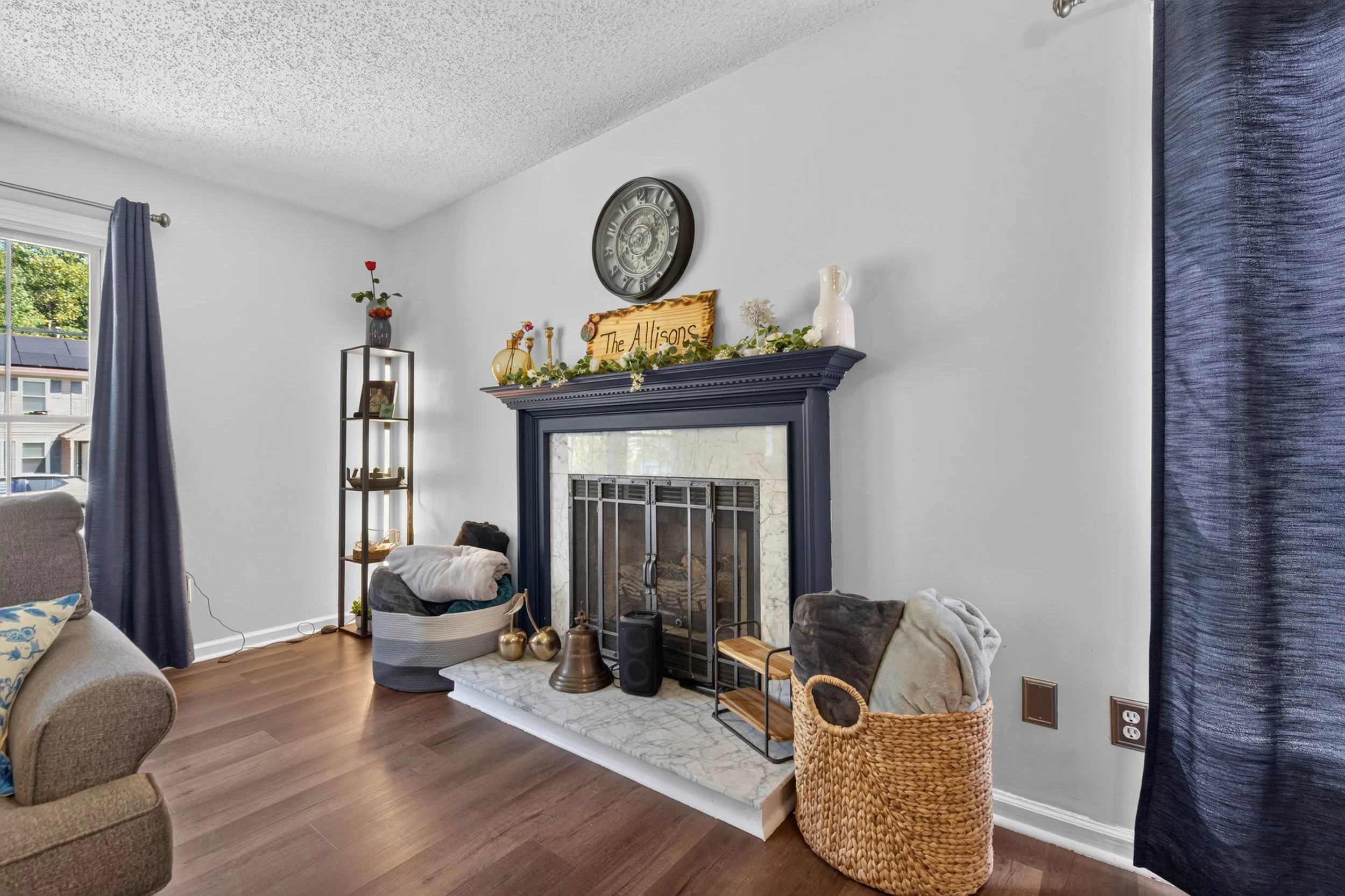 The fireplace sits at the center of the living room, with the staircase and dining area nearby.