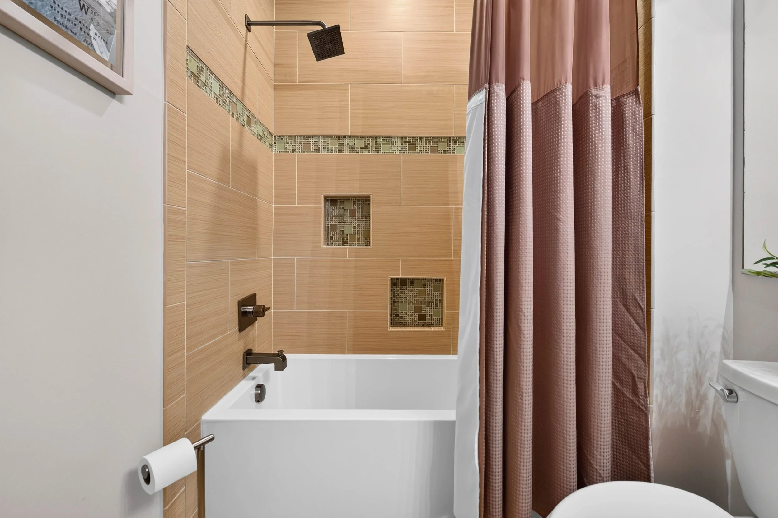 Recessed shower niches and a rain-style showerhead bring thoughtful detail to the renovated hall bathroom.