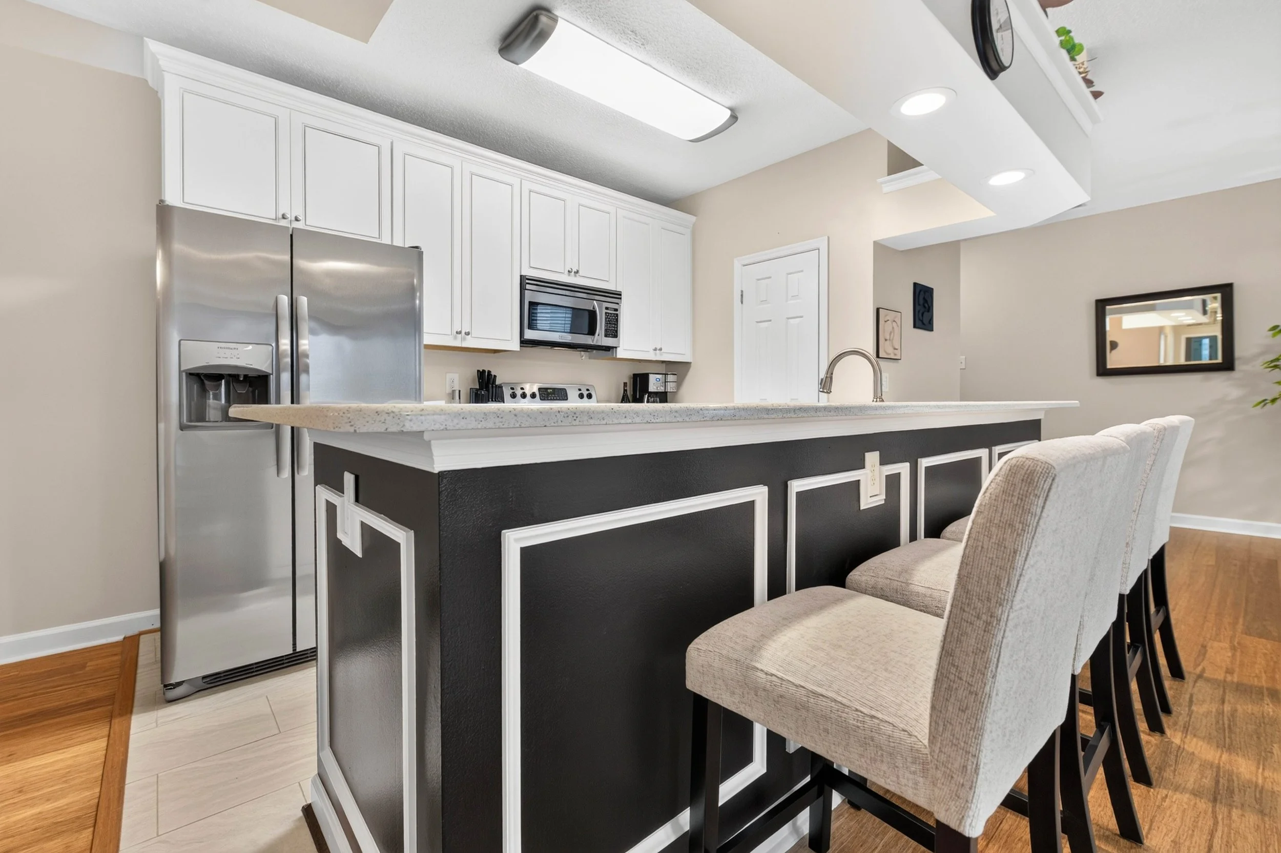 Contrasting trim gives the kitchen peninsula a tailored finish that complements the home’s cohesive interior design.