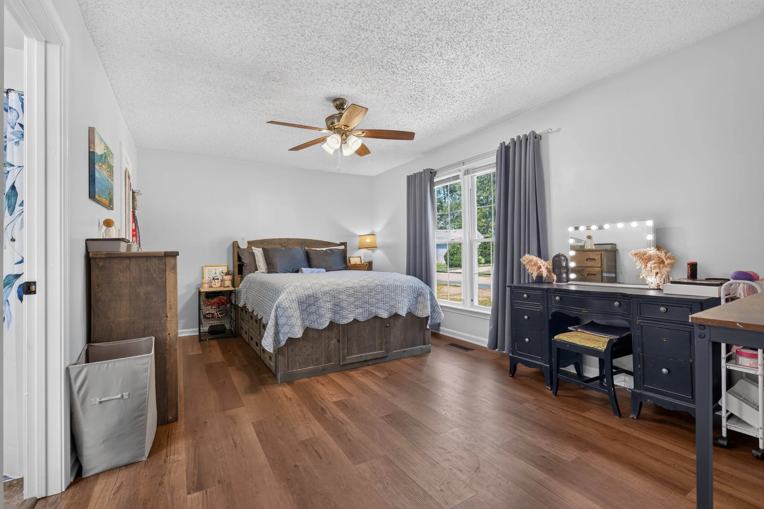 A wide view of the first-floor primary bedroom shows its natural light and overall layout.