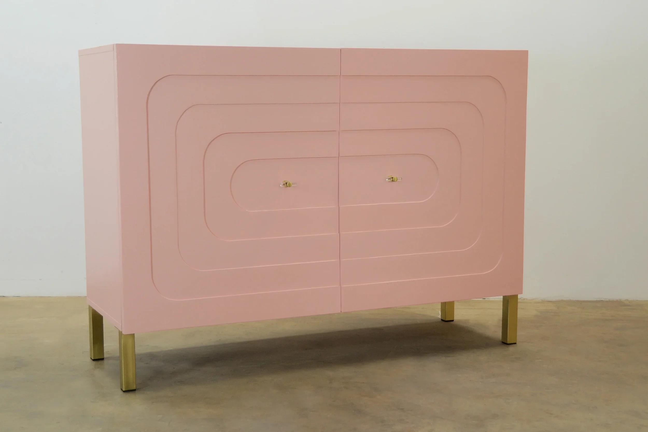 A pink cabinet with a geometric pattern on its doors