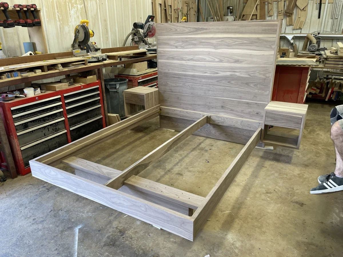 A custom Walnut platform bed getting its first test fitting to make sure everything is just right