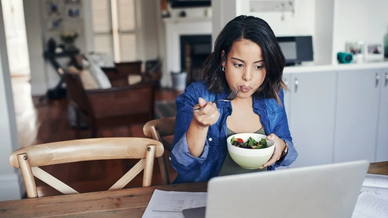 Young_woman_eating_at_desk_laptop_800_450.jpg