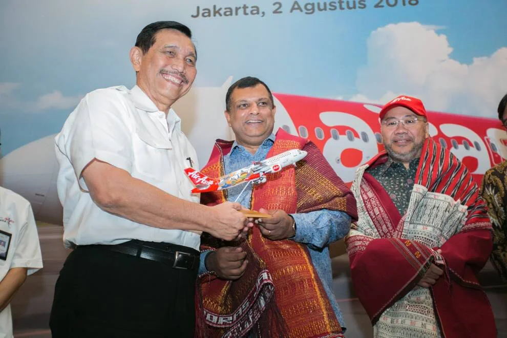 Keterangan Foto: CEO Grup AirAsia, Tony Fernandes (tengah) menyerahkan miniatur pesawat AirAsia kepada Menteri Koordinator Bidang Kemaritiman Republik Indonesia, Luhut Binsar Pandjatian (kiri) disaksikan oleh Executive Chairman Grup AirAsia Berhad dan Co-Group CEO AirAsia X, Datuk Kamarudin Meranun (kanan) saat peluncuran rute Kuala Lumpur - Silangit oleh AirAsia.
