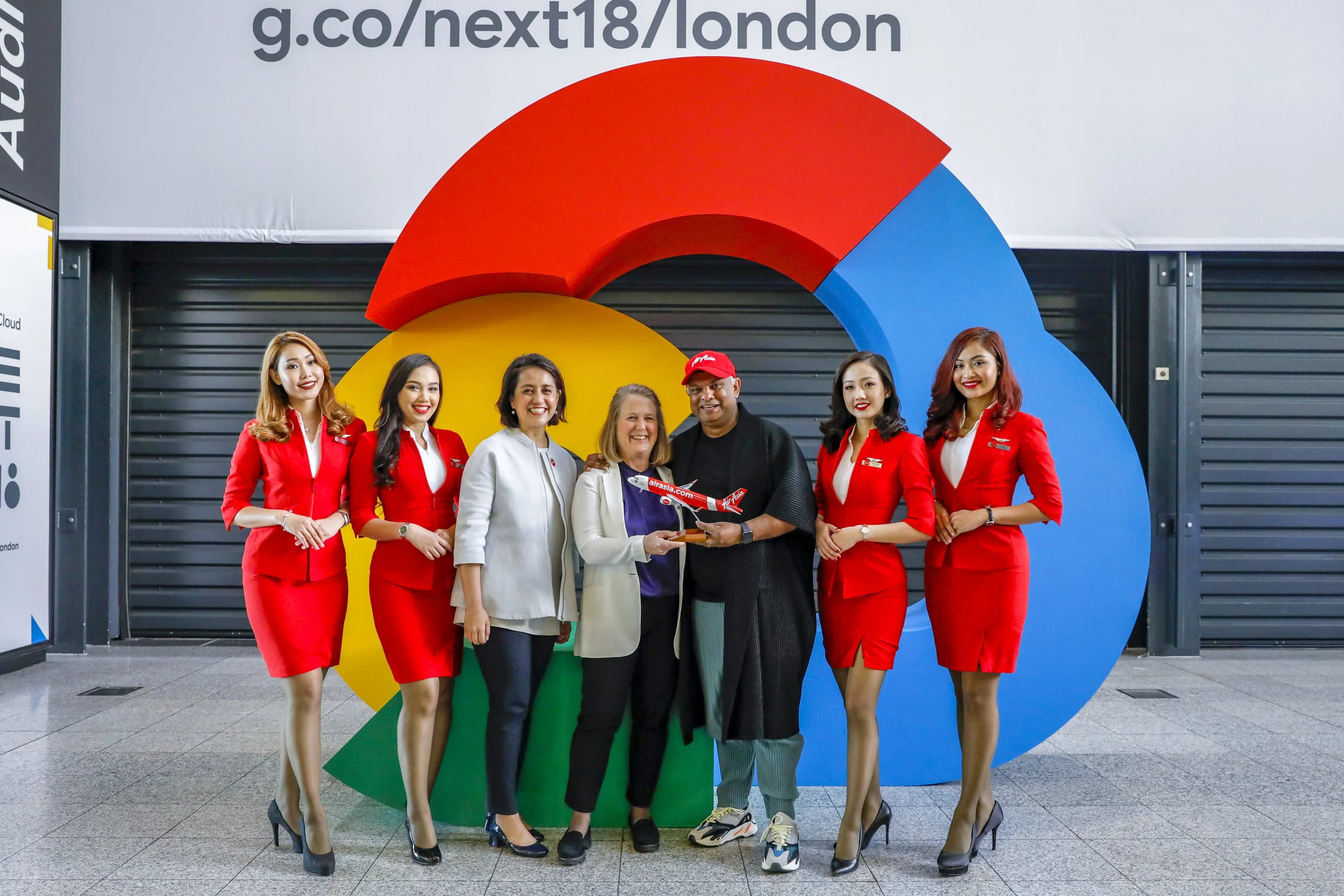 CEO Google Cloud Diane Green (tengah), CEO Grup AirAsia Tony Fernandes, dan Deputi CEO Grup AirAsia bidang Digital, Transformasi dan Layanan Korporasi Aireen Omar diapit oleh awak kabin AirAsia pada acara Google Cloud NEXT ‘18 di London.
