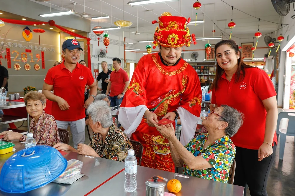 Photo caption: AirAsia X Malaysia CEO Benyamin Ismail decked in God of Prosperity costume distributes ang pau to the residents of Chik Sin Thong Klang & Pantai Old Folks' home this afternoon.