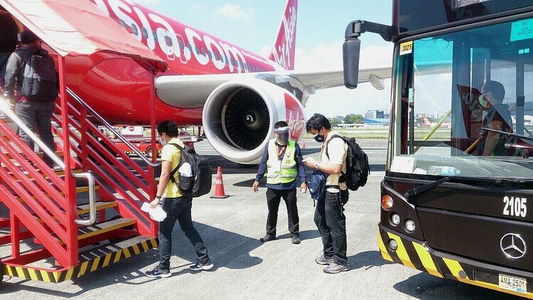 Guests practicing physical distancing as they board the aircraft.