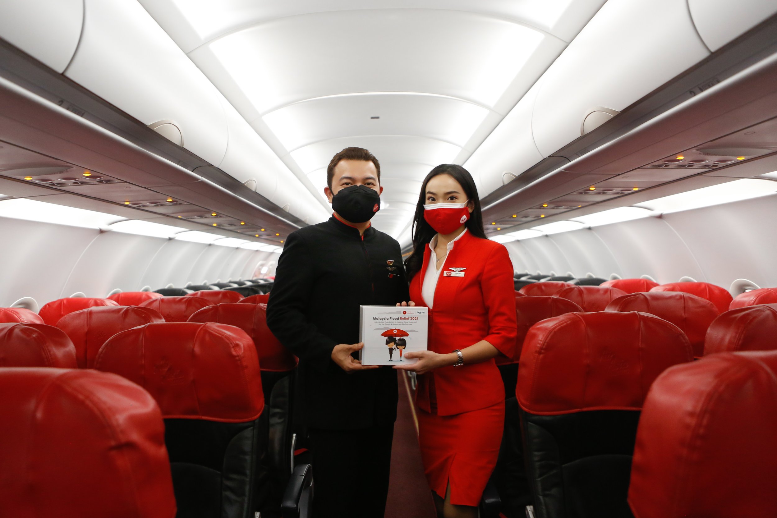  Photo Caption: Kru kabin AirAsia mengutip sumbangan kempen Bantuan Banjir Malaysia oleh AirAsia Foundation di dalam penerbangan AirAsia baru-baru ini. 