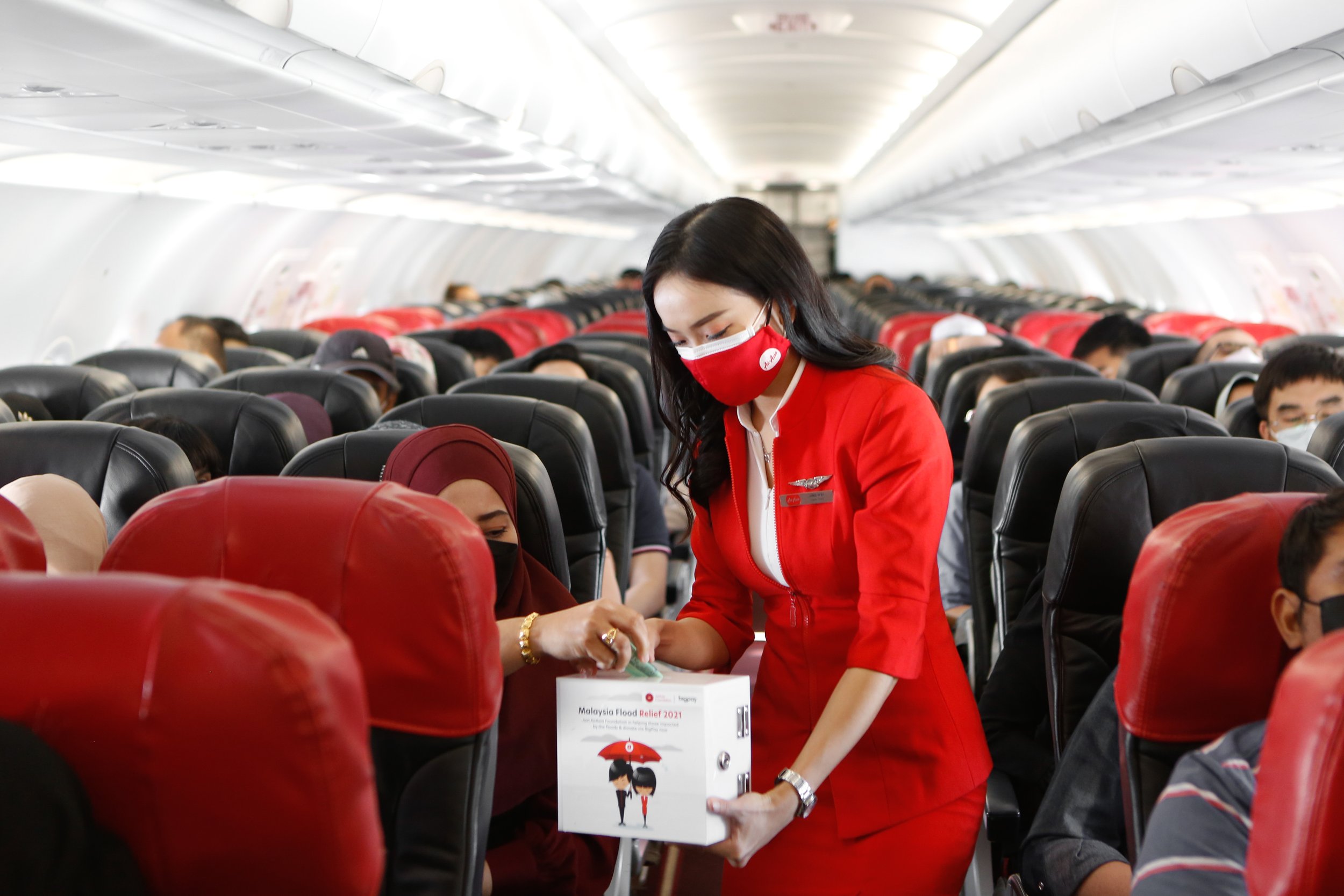  Photo Caption: AirAsia cabin crew collecting a donation for the Malaysia Flood Relief campaign by AirAsia Foundation onboard recently. 