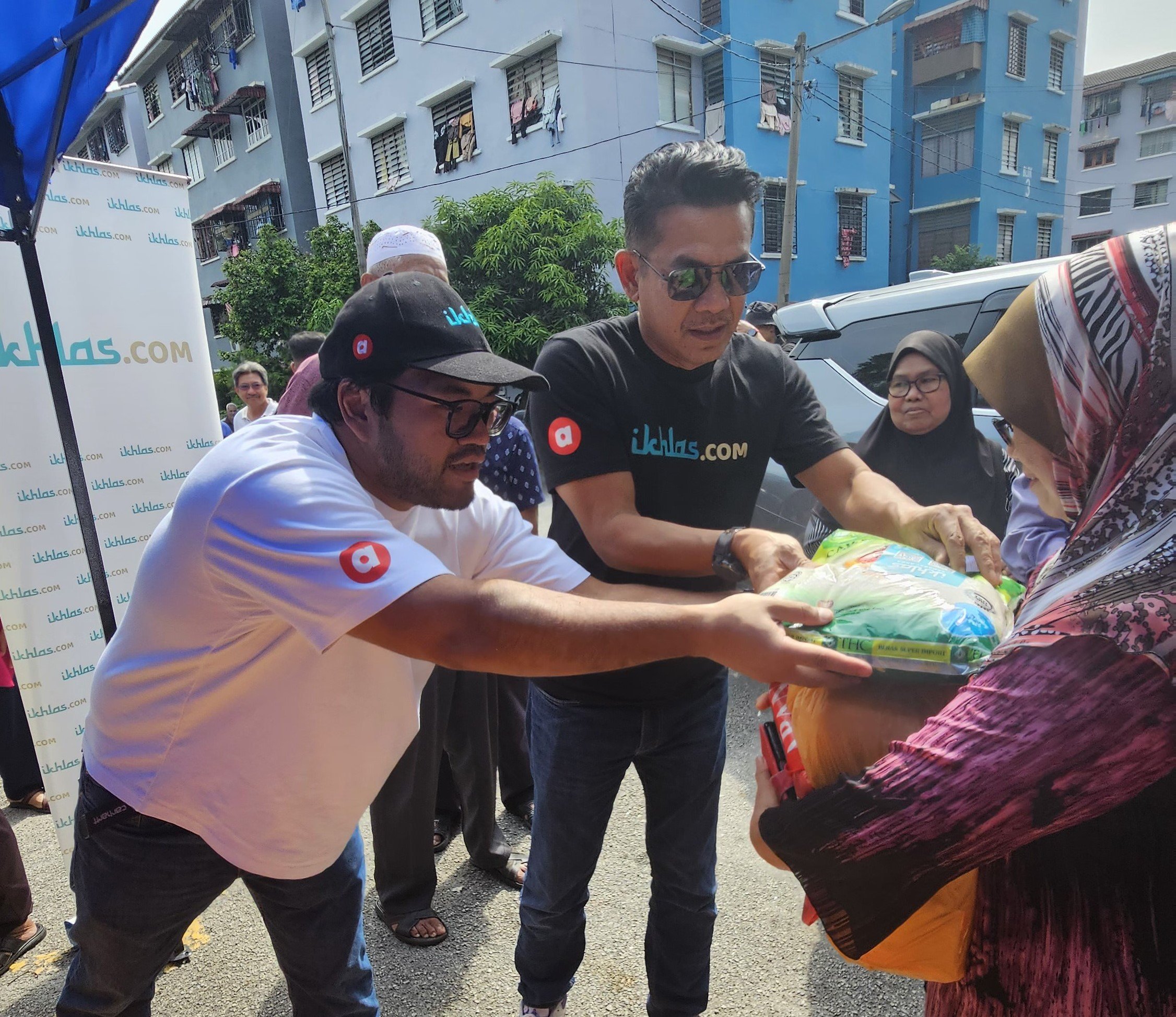  (Dari kiri) Ikhlas Kamarudin dan Datuk Rosyam Nor menyerahkan bakul makanan kepada penerima di Pantai Dalam, Kuala Lumpur. 