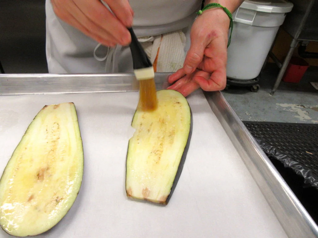 Slice the eggplant lengthwise into 1/2 inch thick slices. Brush with olive oil, place on cookie sheet and broil until golden brown.