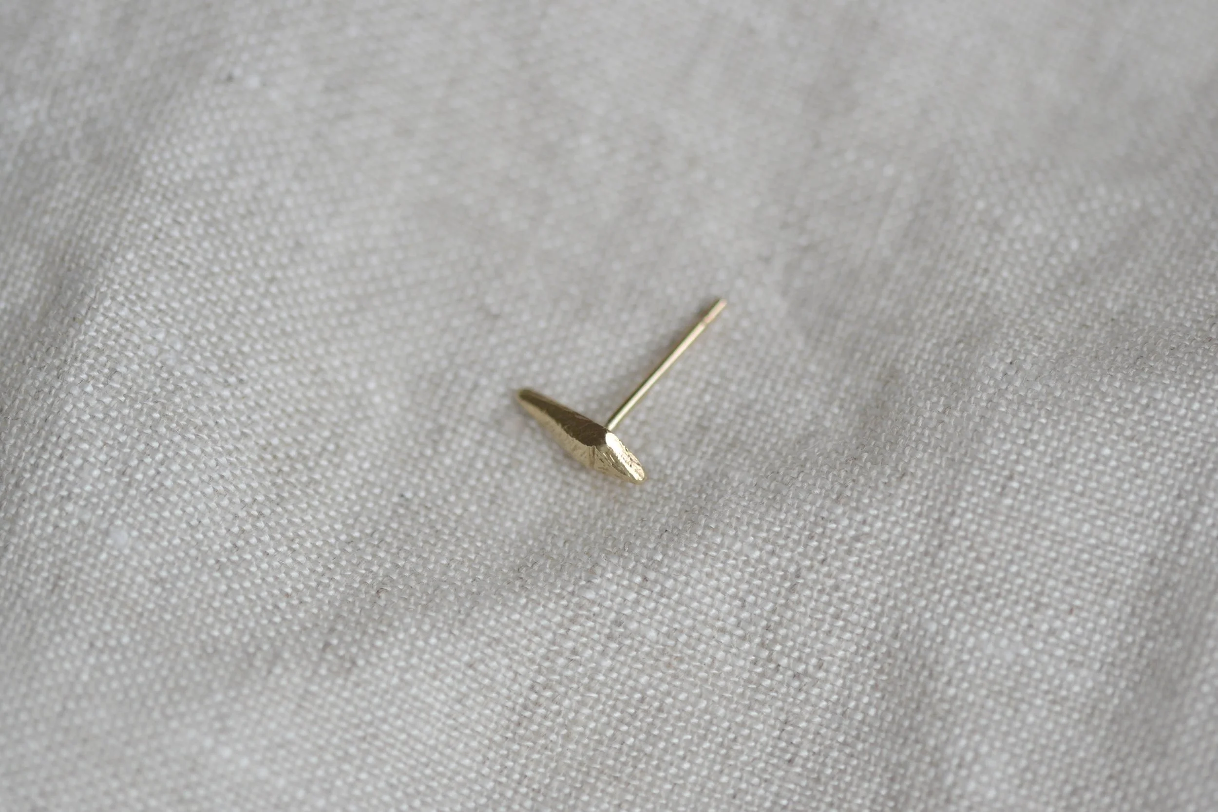 gold kite stud in flatlay view