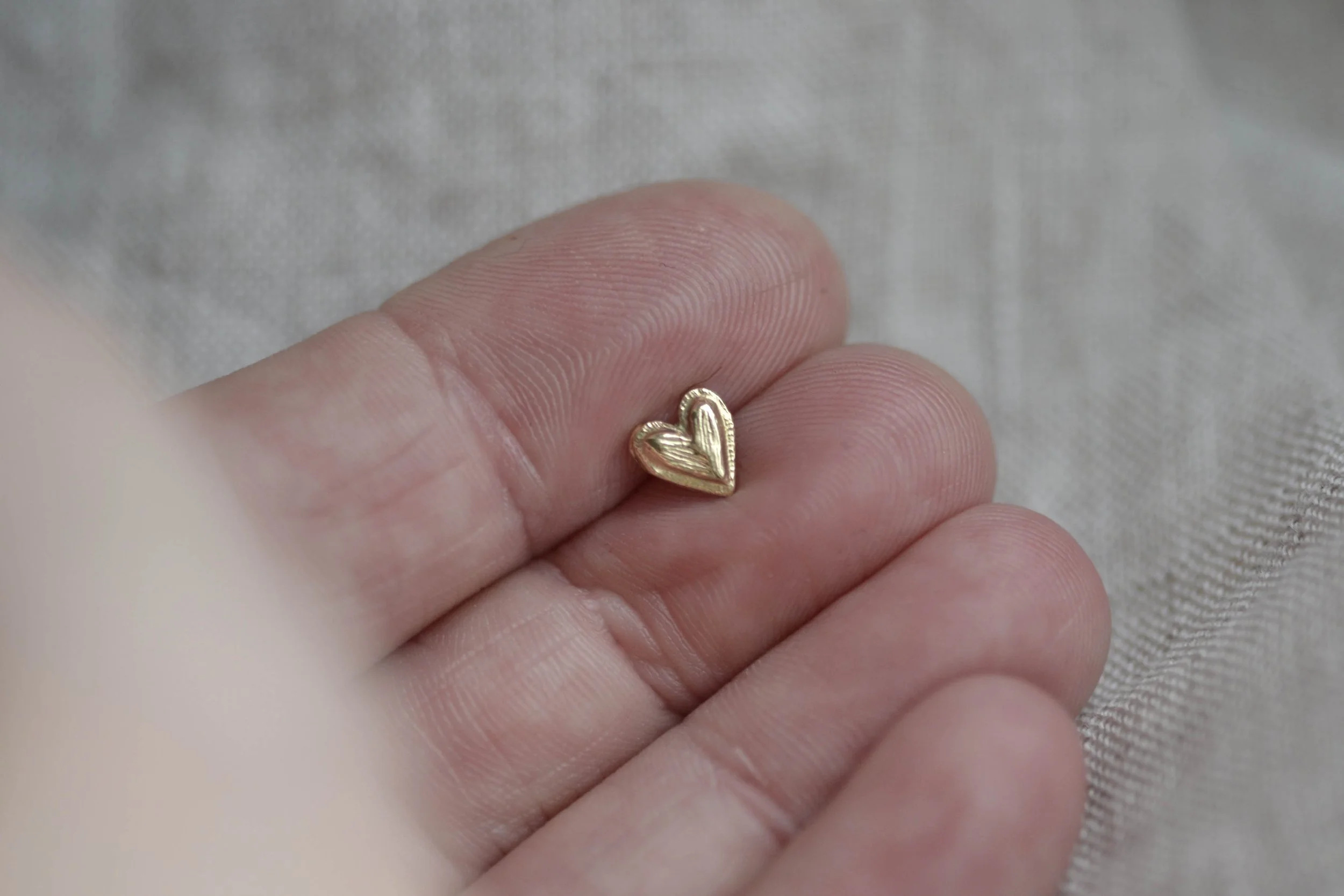 hand holding heart studs