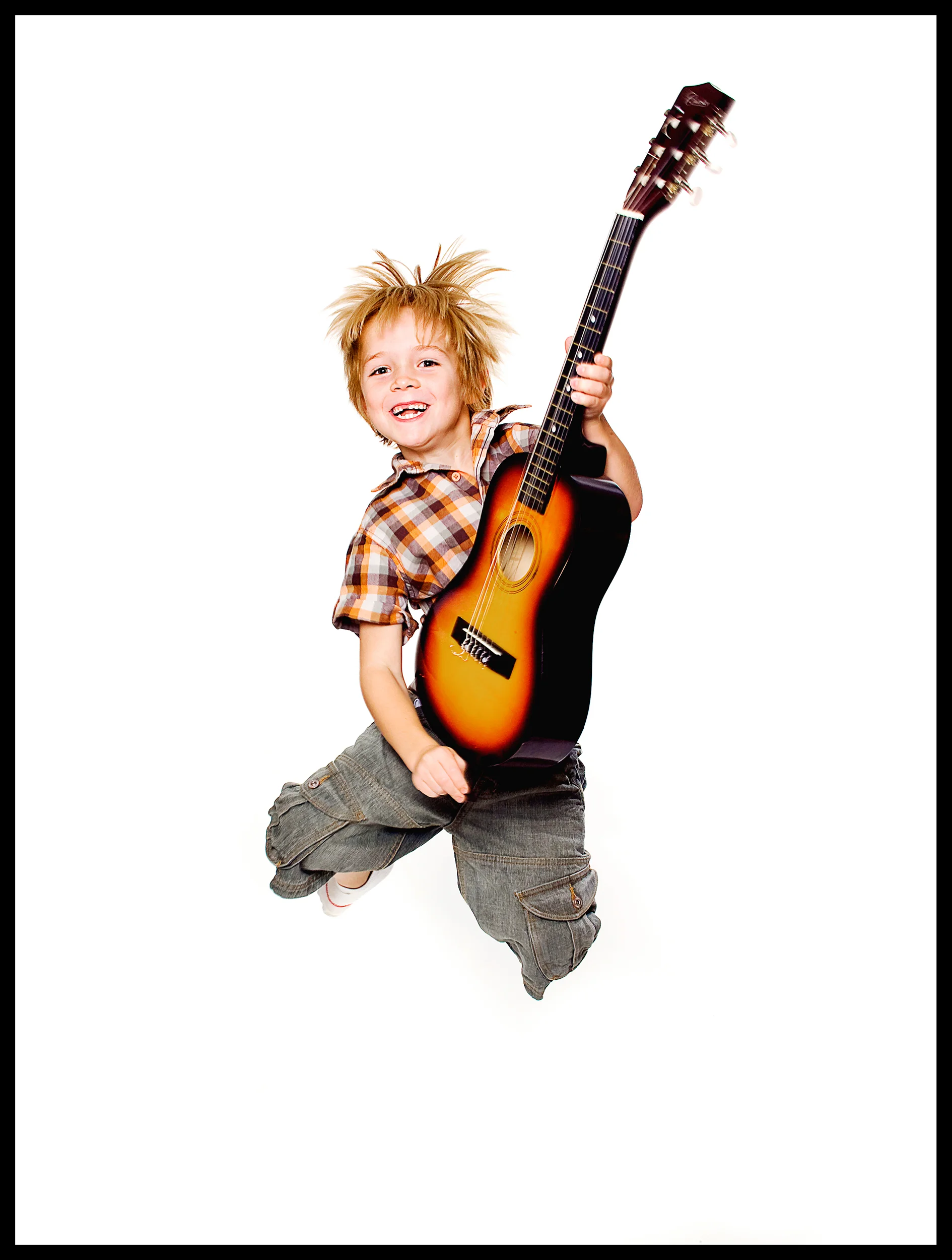 portrait of blonde boy with a guitar jumpin