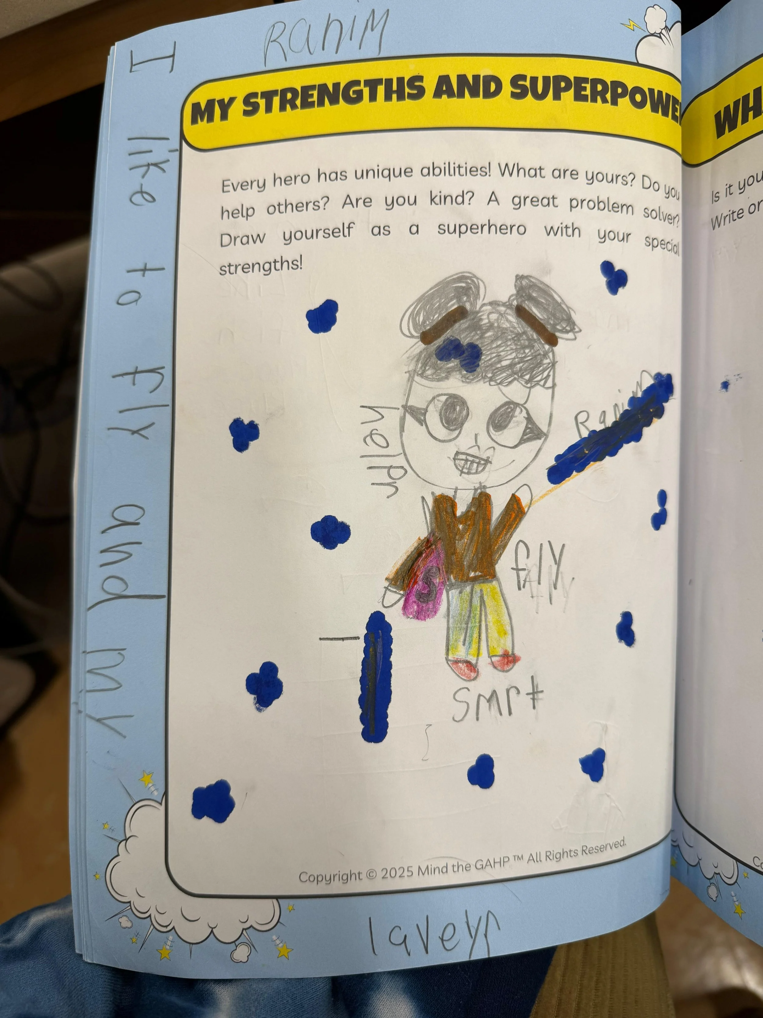 A colorful children's drawing and writing about superhero strengths and abilities. It features a hand-drawn figure in a superhero costume with large eyes, a smile, and a cape, surrounded by blue stars or clouds. The handwritten words include 'my' and