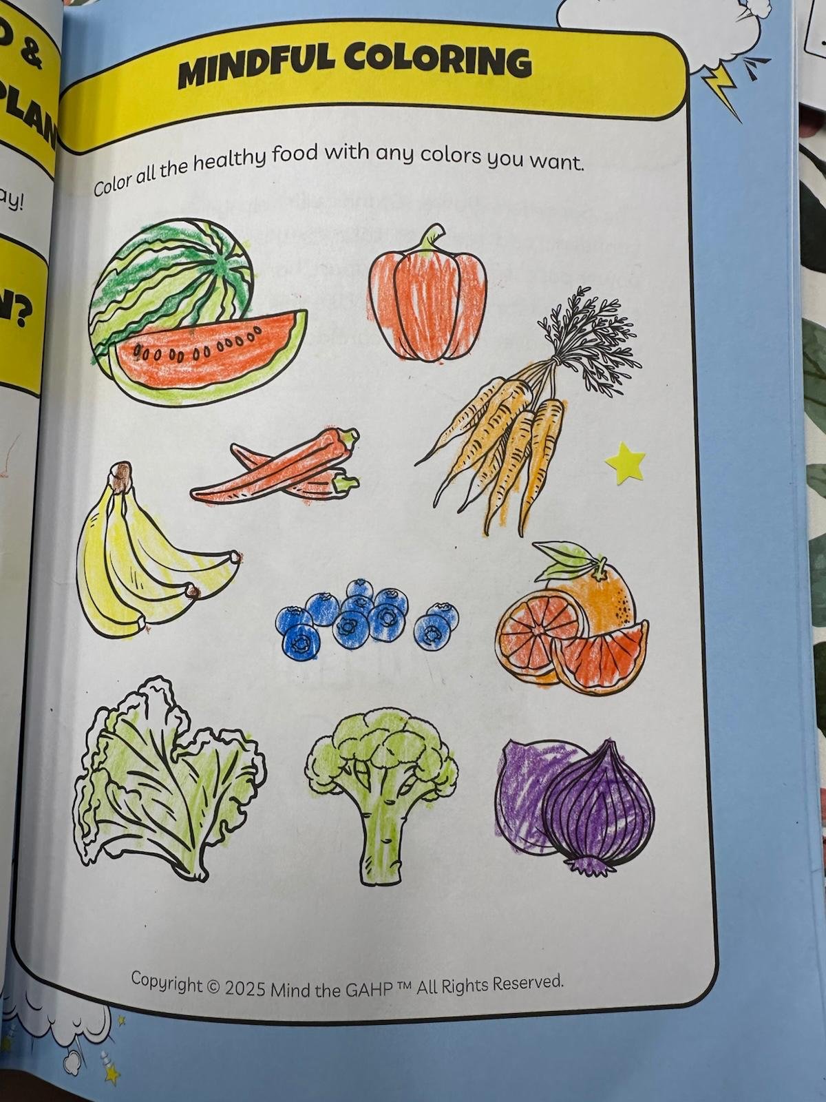 A coloring page titled 'Mindful Coloring' with illustrations of healthy foods, including a watermelon, bell pepper, carrots, bananas, blueberries, an orange, lettuce, broccoli, and a purple onion, all partially colored with crayons.