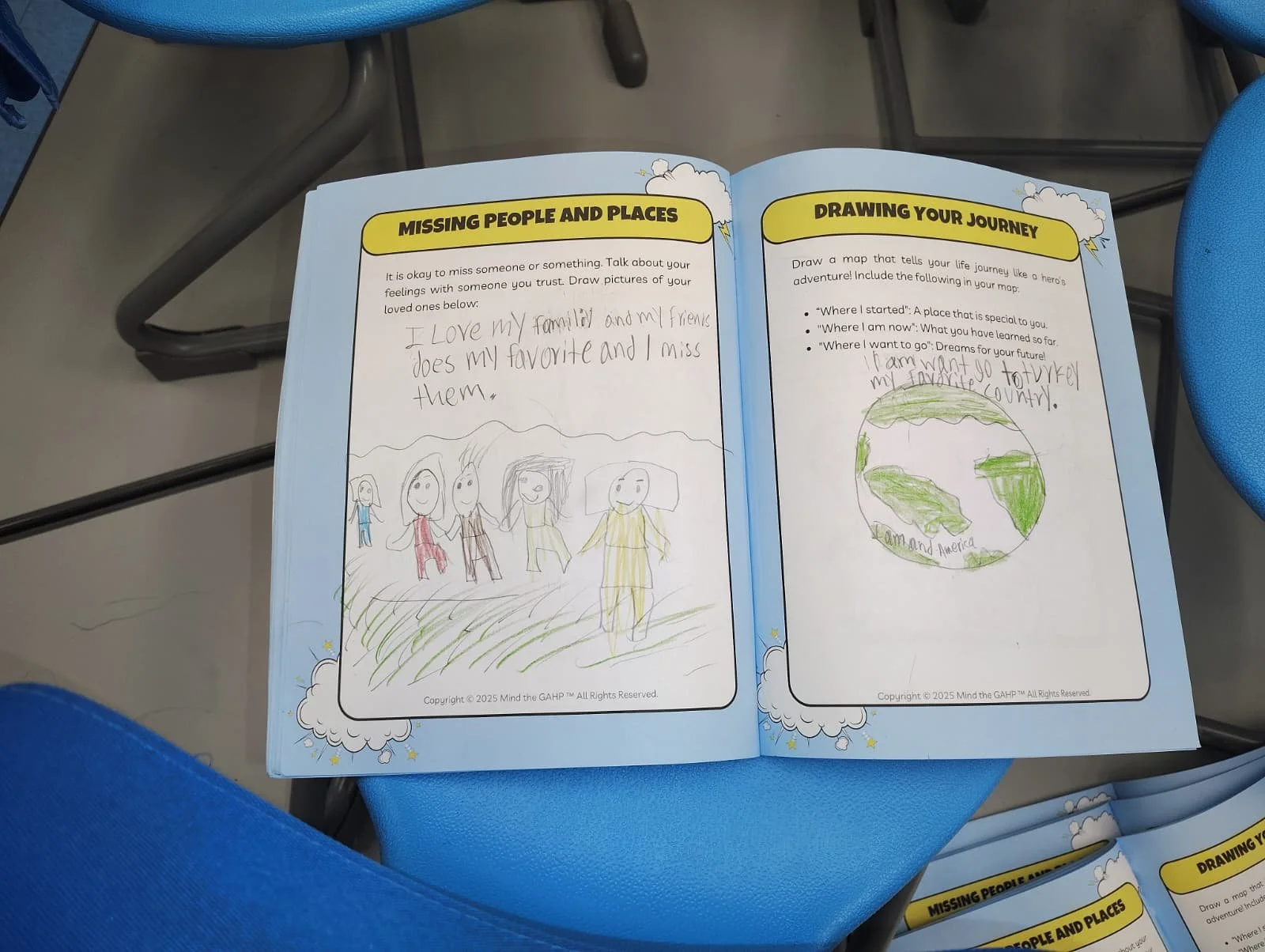 A children's workbook page with handwritten text and colorful drawings. The left page has a story about missing loved ones with a drawing of five people and a dog. The right page features a drawing of the Earth and prompts for drawing a life journey 