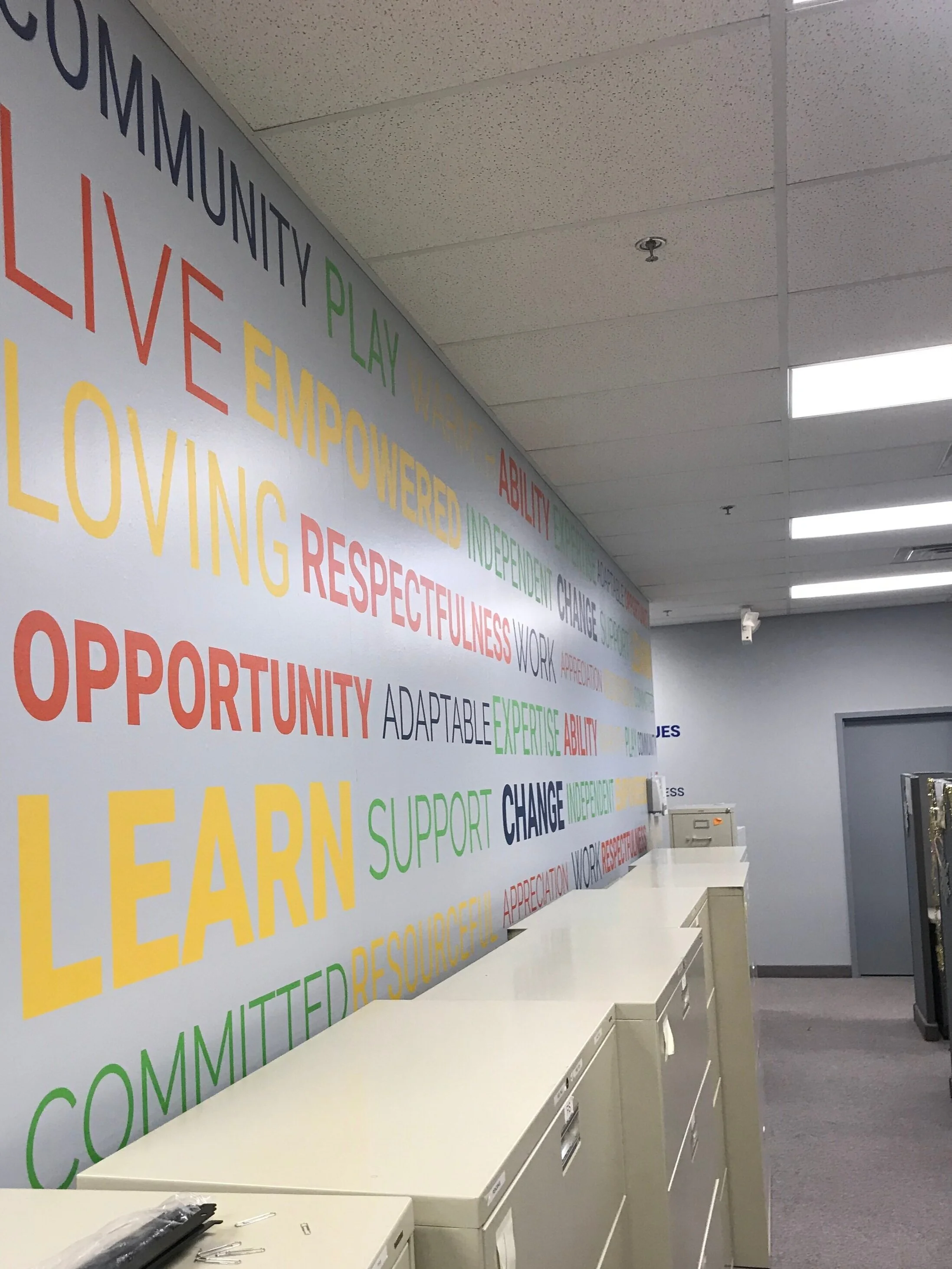  This new wing of the building added a separate entrance, which allowed for both fun and useful directional graphics. Using our theme of circles to encompass this element, we were able to point to each meeting room, named after the organization’s thr