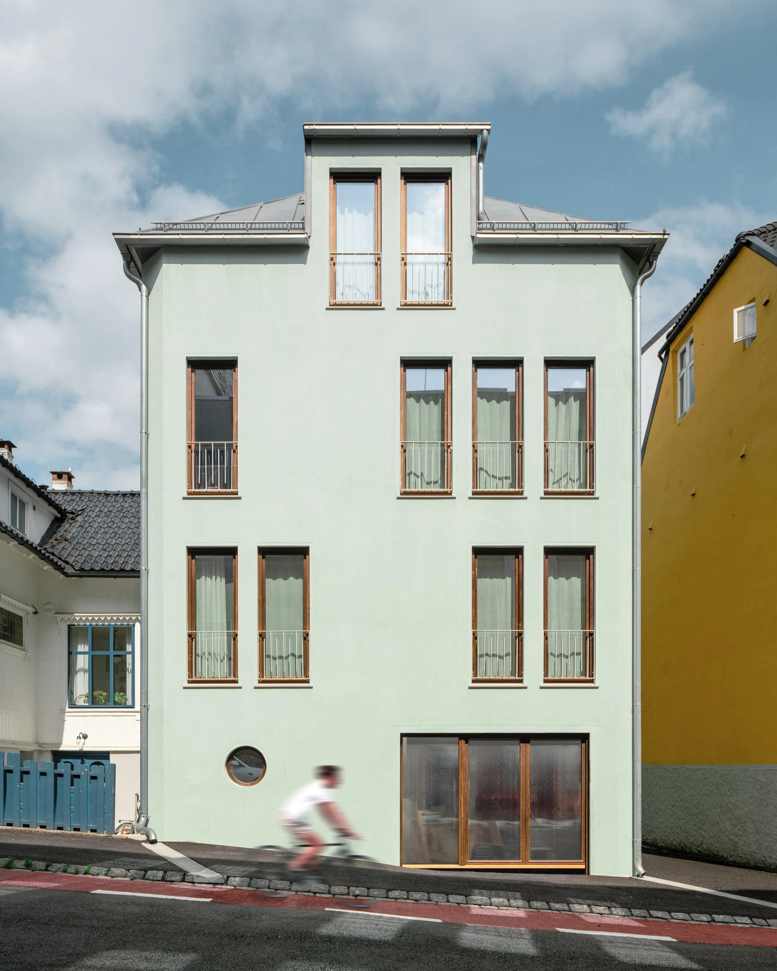 Jonas Reins Gate 11 Et hus designet for en familie som ønsker å bo i byen, en frittliggende enebolig i fire etasjer i et tettbebygget boligstrøk. Bygget er gitt en hovedform som er tilpasset omgivelser i plassering, takform og fargebruk; et infill
