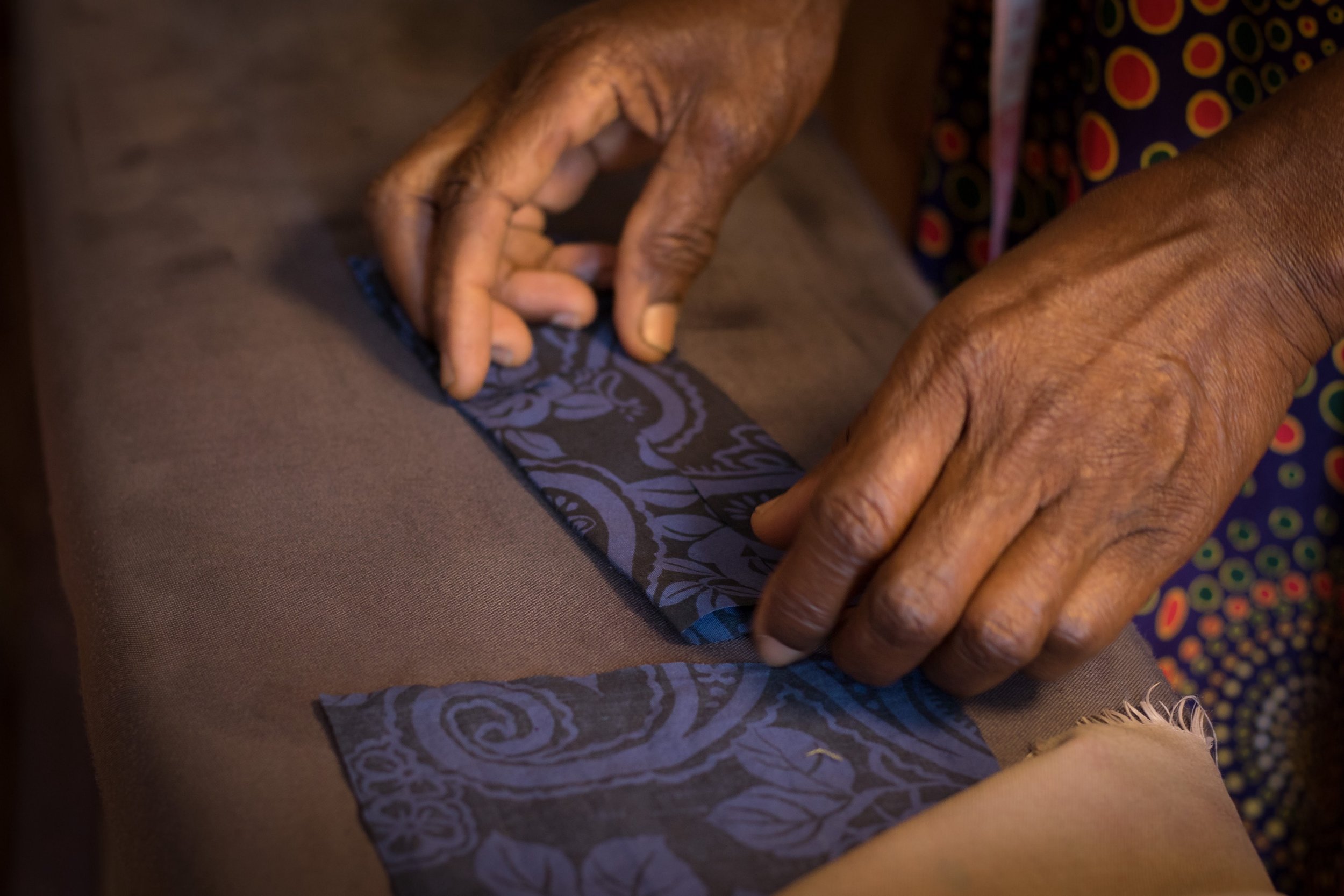 Marjorie, one of our talented tailors, making a bow tie from fabric offcuts.