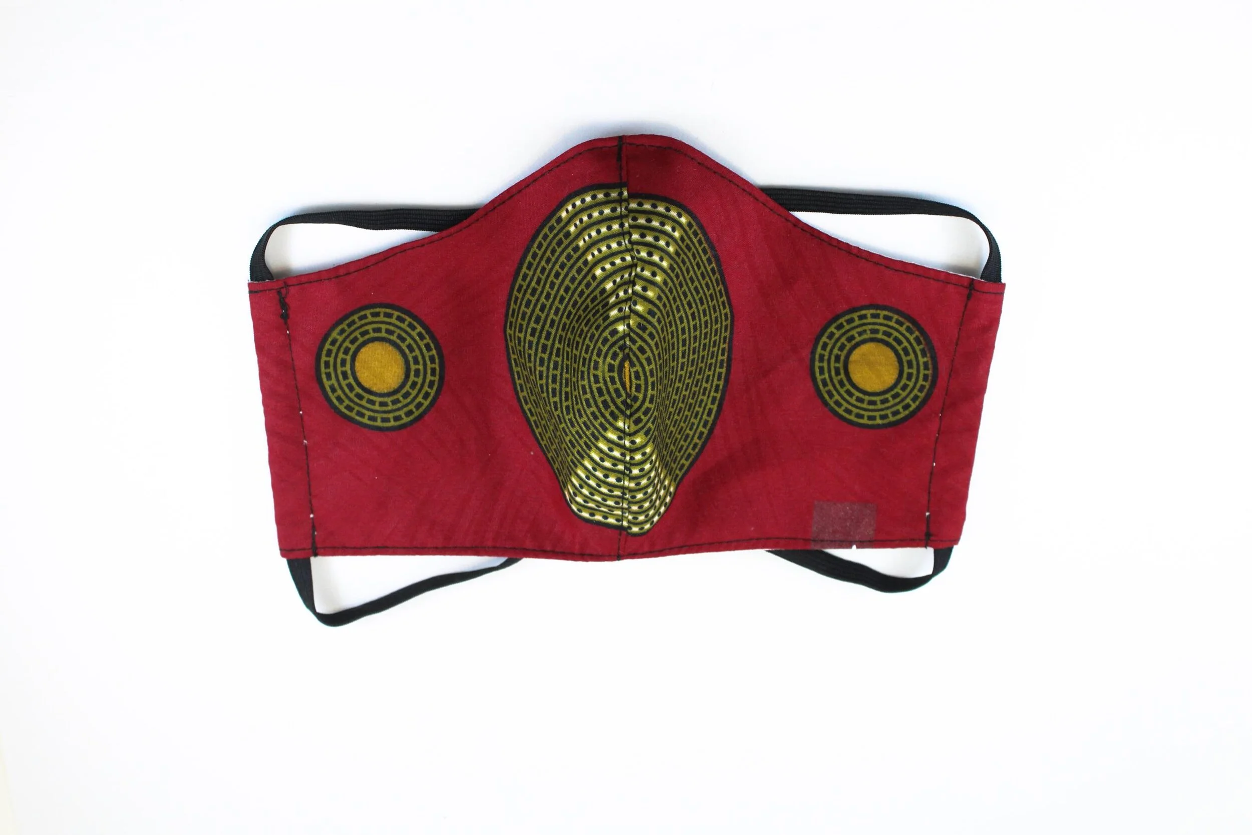 A red face mask with green and yellow emblems