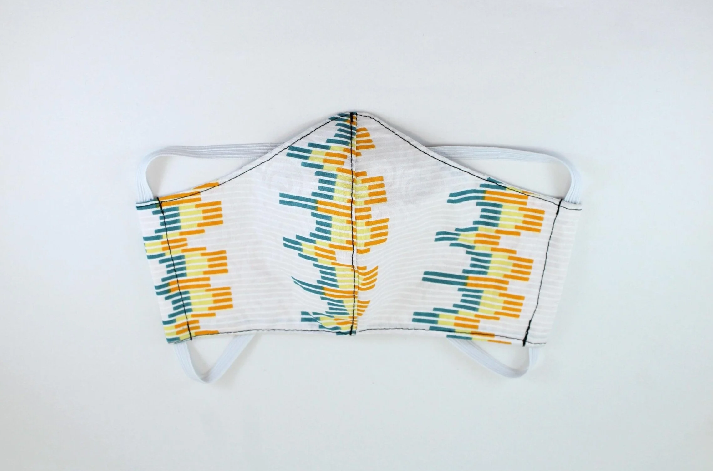 A white face mask with a yellow and blue pattern