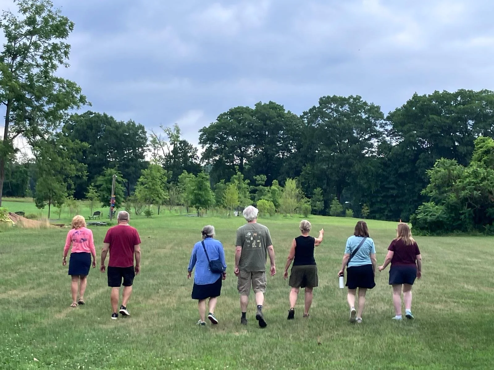 A group of people walk through a field at a Hikes and History Cruise.
