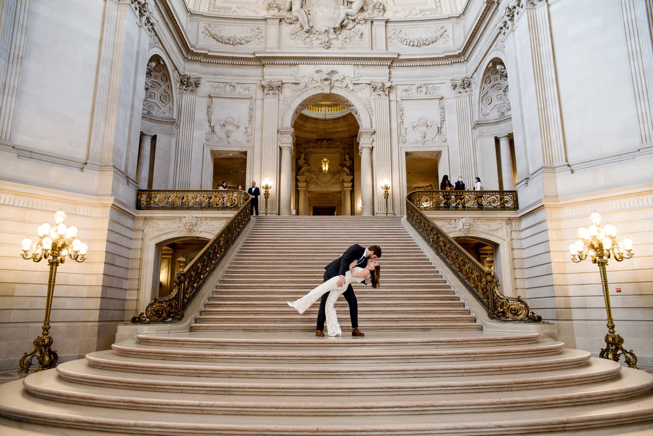  Bride and Groom kiss on the staircase at San Francisco City Hall on their wedding day. 