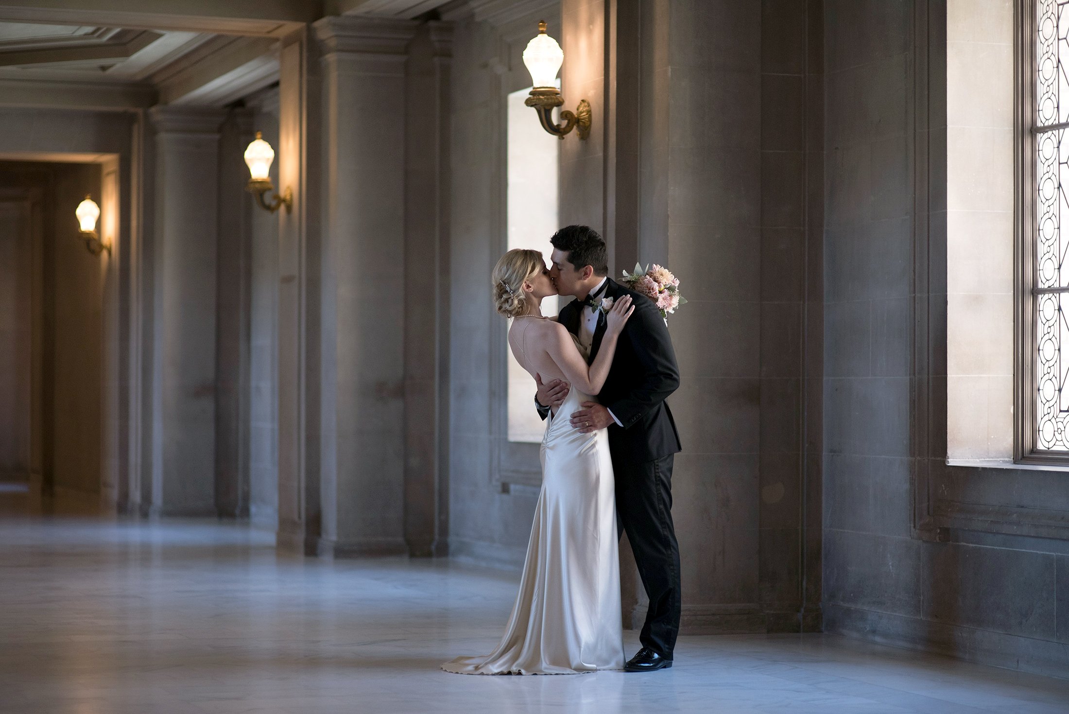  Bride and Groom kiss on the second floor at San Francisco City Hall on their wedding day. 