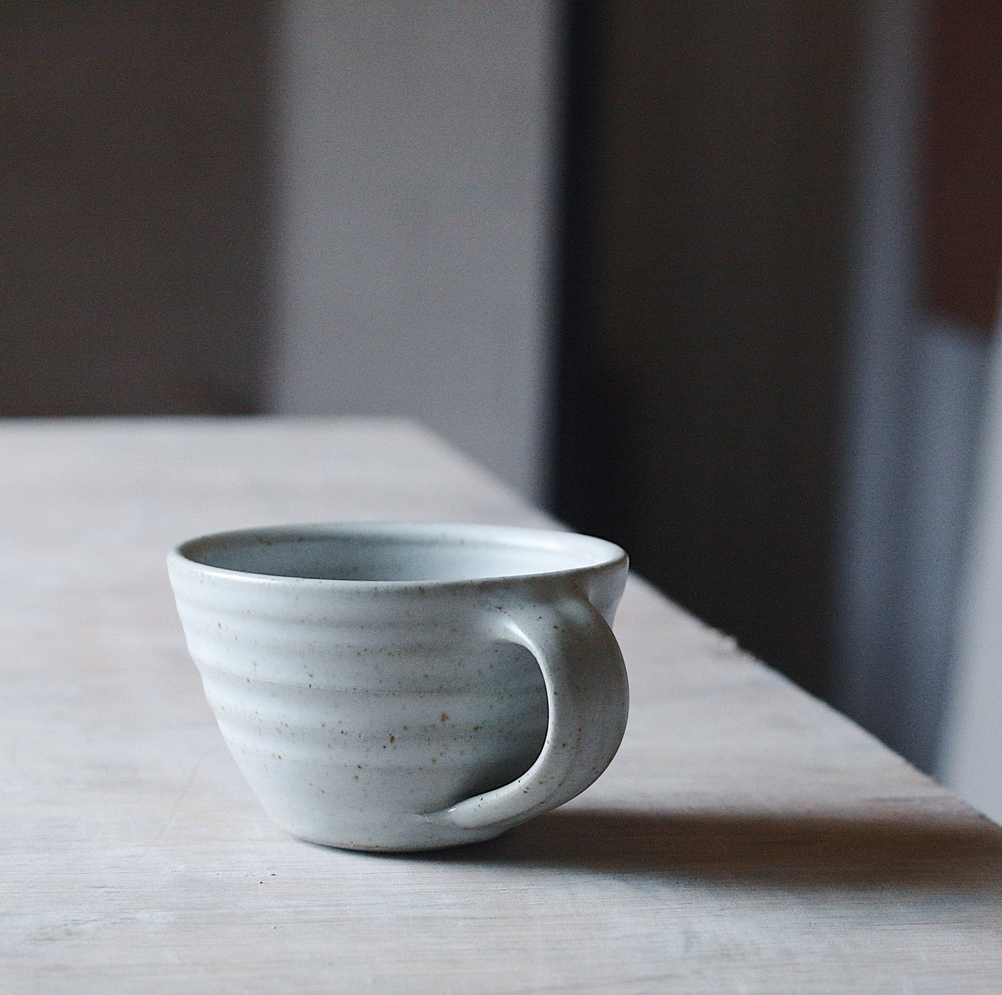A soft satin white coffee cup. A new shape for me in the new studio. Thrown a little thicker than normal and it really shows in the finished pot. The whole aesthetic is a little gentler and more inviting. Excited to get these out into the world at @p
